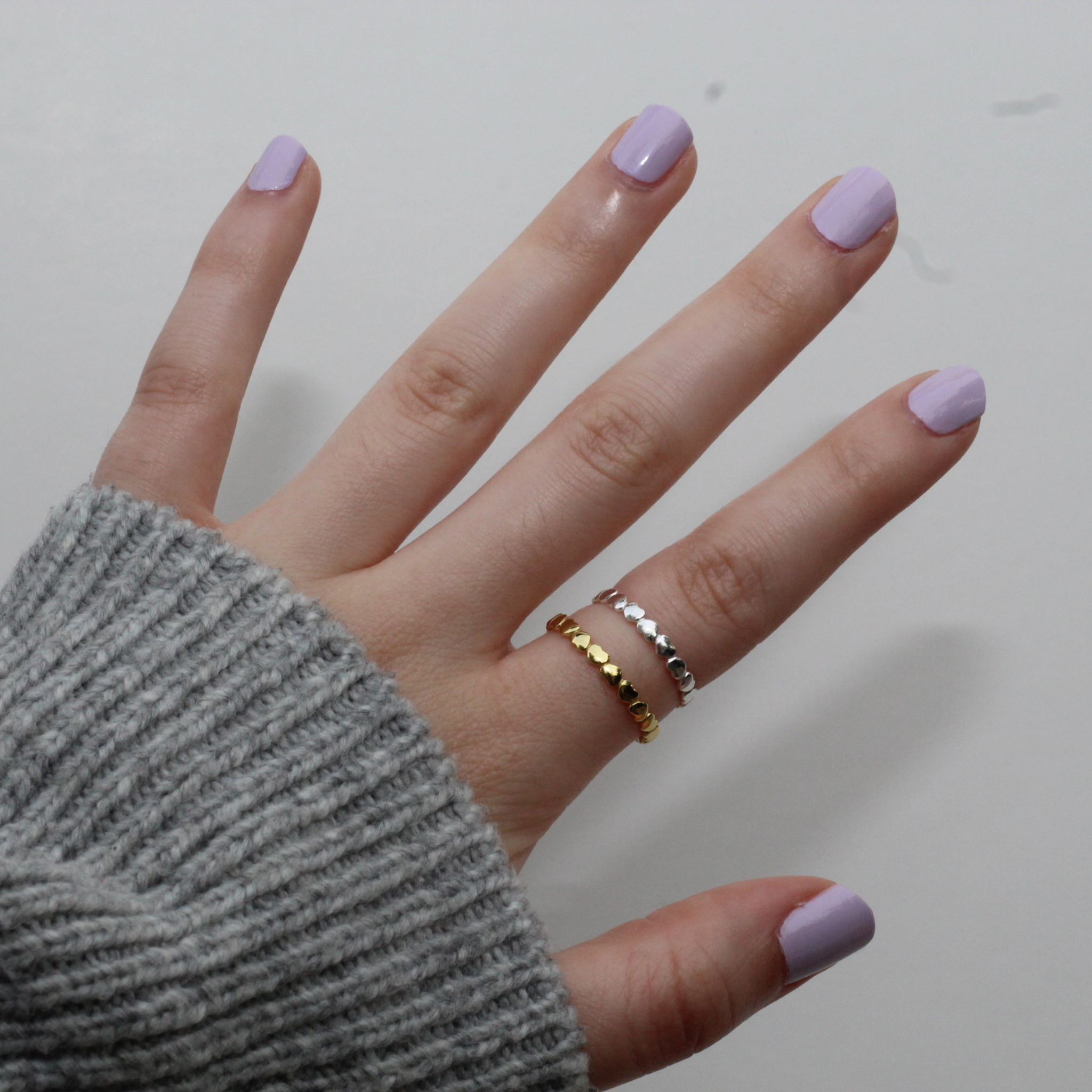 A delicate Circle of Love Ring made of sterling silver and gold, symbolizing love and support, displayed in an elegant anti-tarnish jewelry bag.