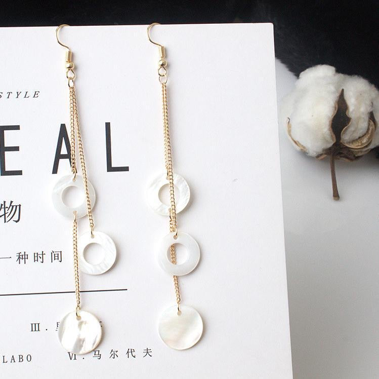 A pair of elegant Circle Shells Long Earrings made from natural shell, showcasing a unique circular design.