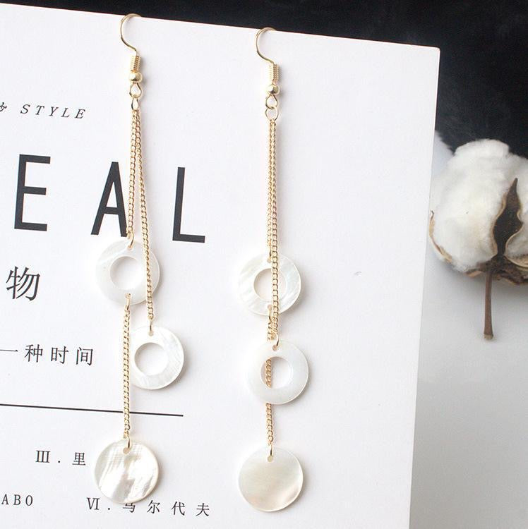 A pair of elegant Circle Shells Long Earrings made from natural shell, showcasing a unique circular design.