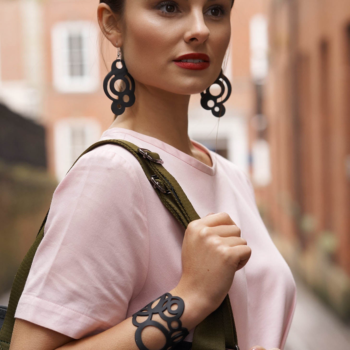 Circular Inner Tube Earrings made from reclaimed rubber, featuring a unique design with eccentric circles and sterling silver hooks.