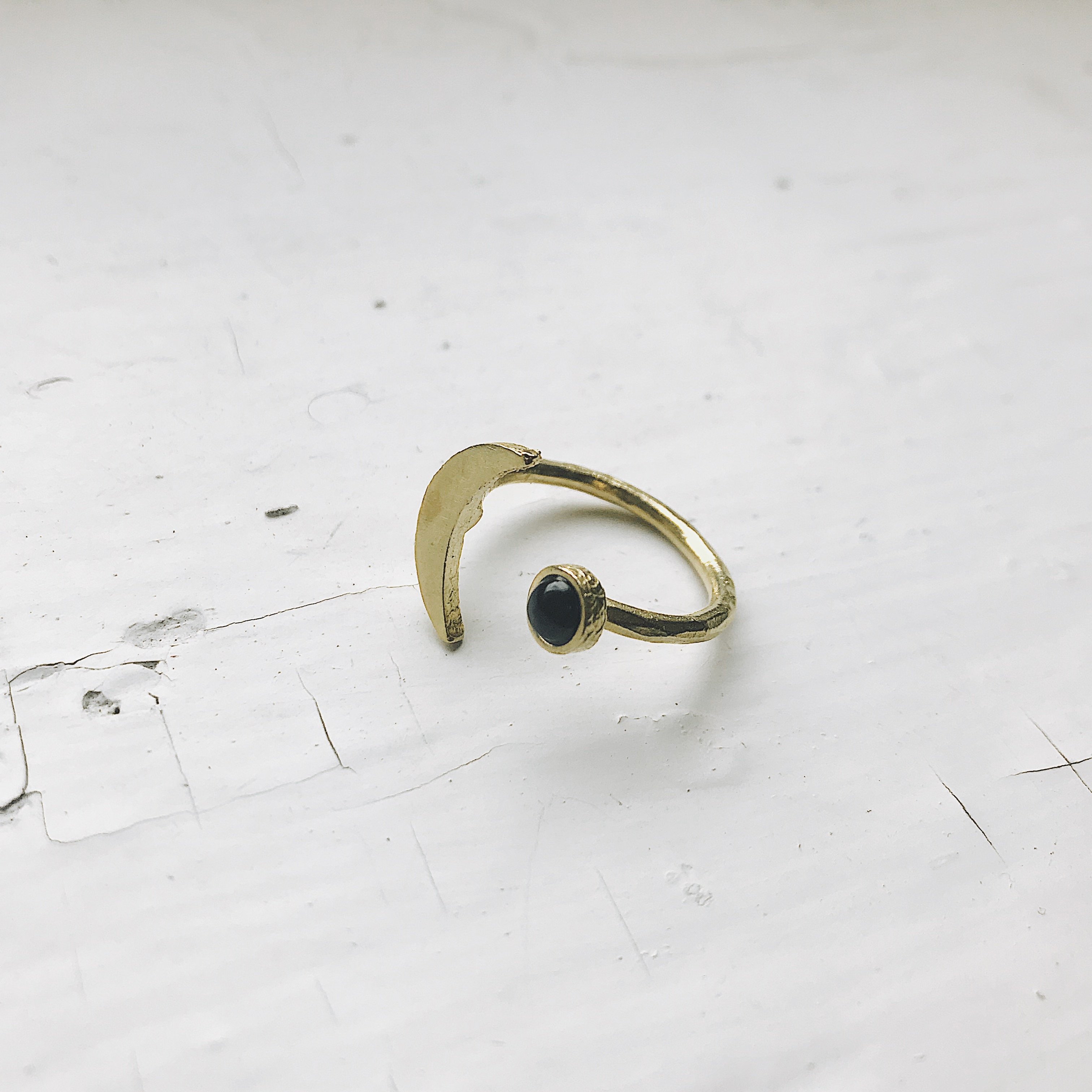 A beautifully handcrafted Crescent Moon Ring featuring a black onyx stone, available in silver or gold tone, showcasing its unique design.