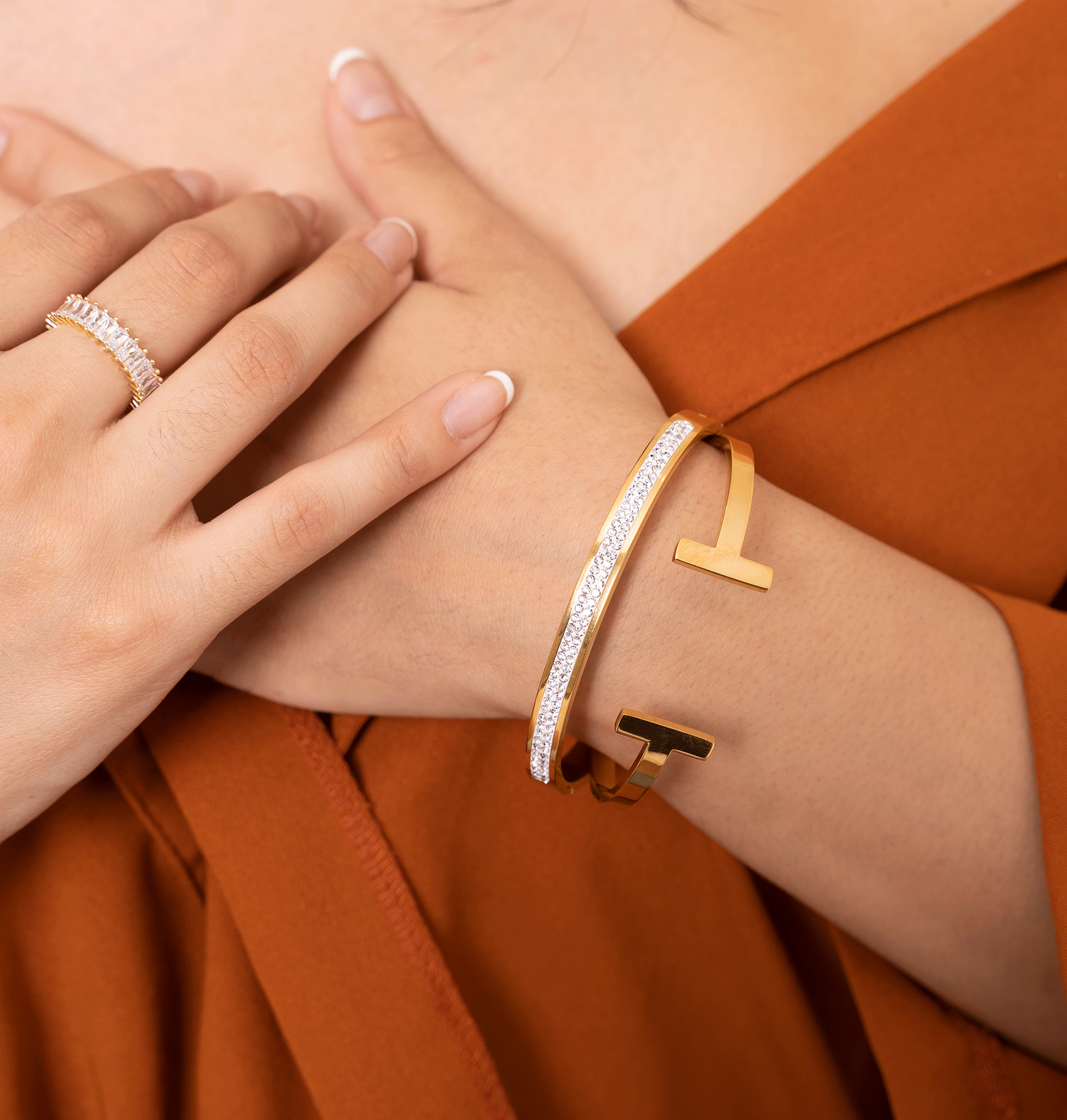 The CLEO Cuff is a stylish open bangle with a geometric 'T' shaped top, featuring 18K gold plating over stainless steel.