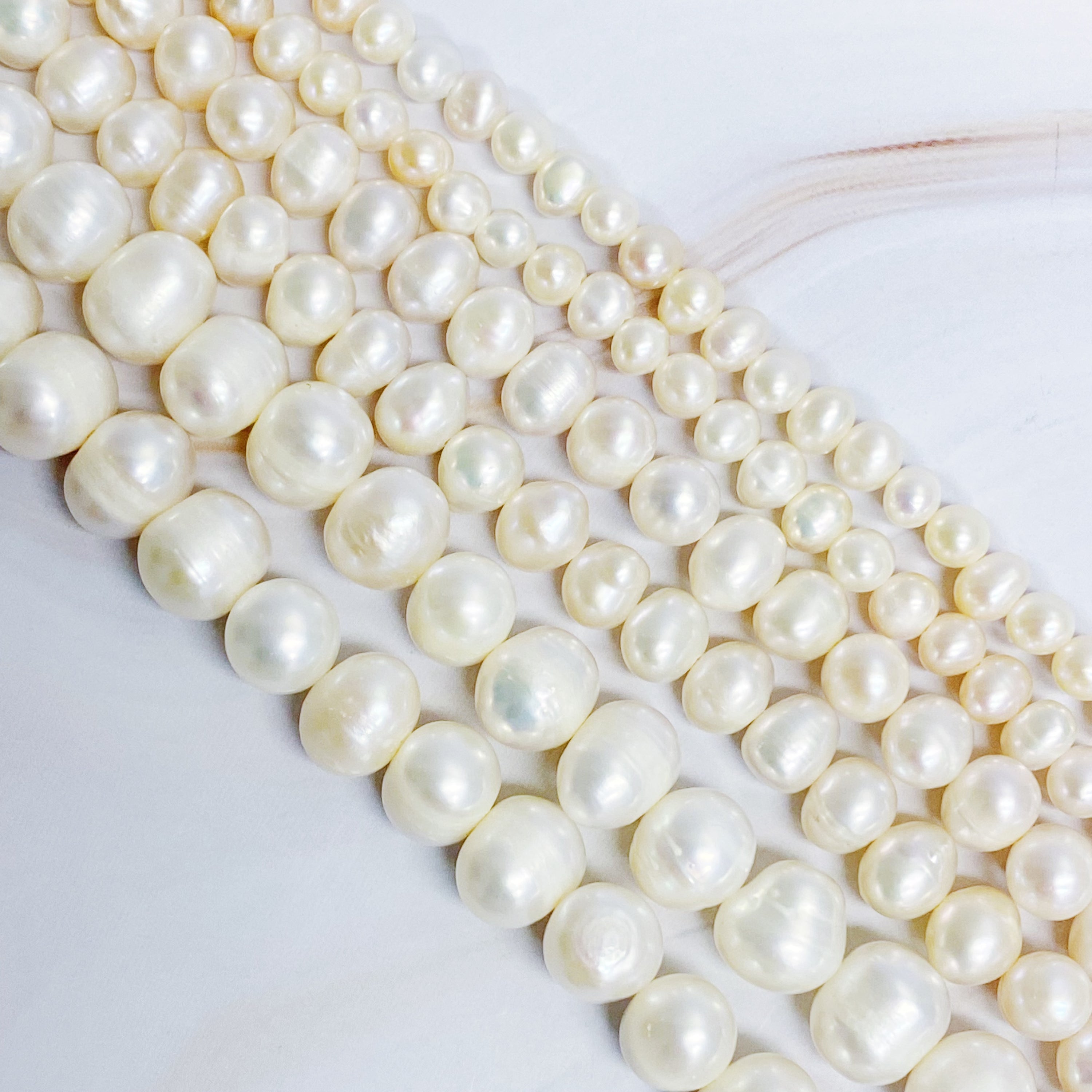 Clover Clasp Genuine Pearl Necklace featuring freshwater pearls in various sizes and an elegant 18k gold dipped sterling silver clasp.