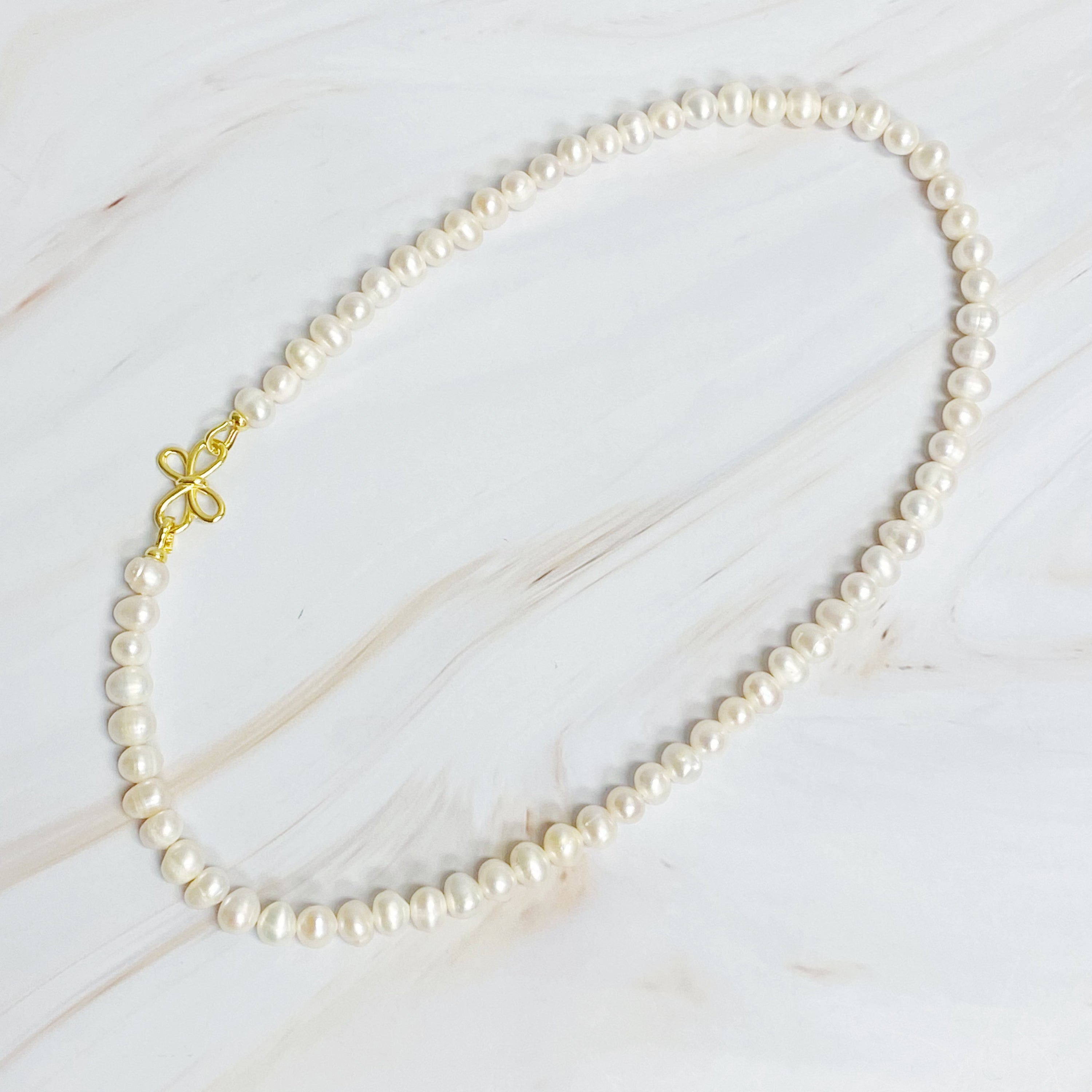 Clover Clasp Genuine Pearl Necklace featuring freshwater pearls in various sizes and an elegant 18k gold dipped sterling silver clasp.