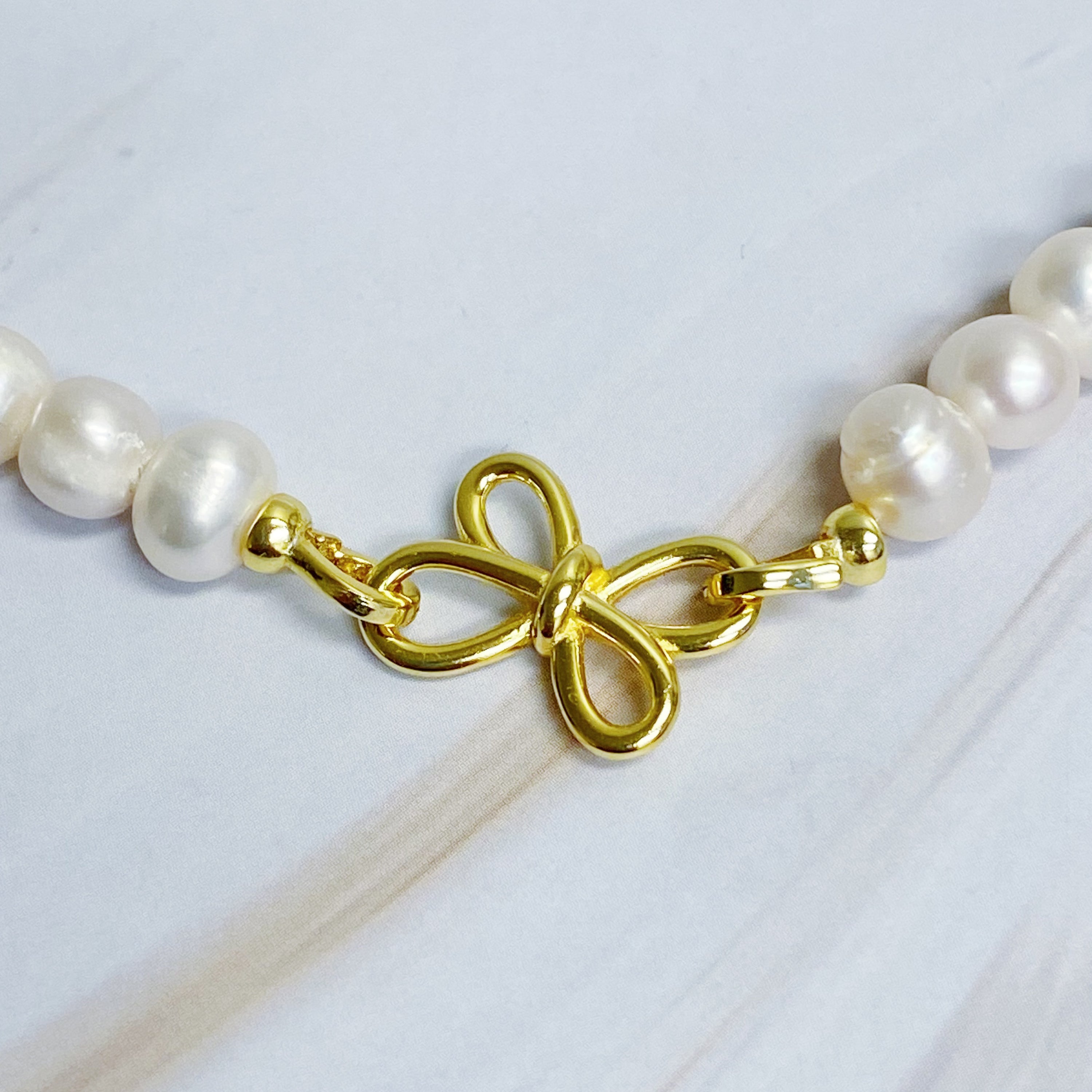 Clover Clasp Genuine Pearl Necklace featuring freshwater pearls in various sizes and an elegant 18k gold dipped sterling silver clasp.