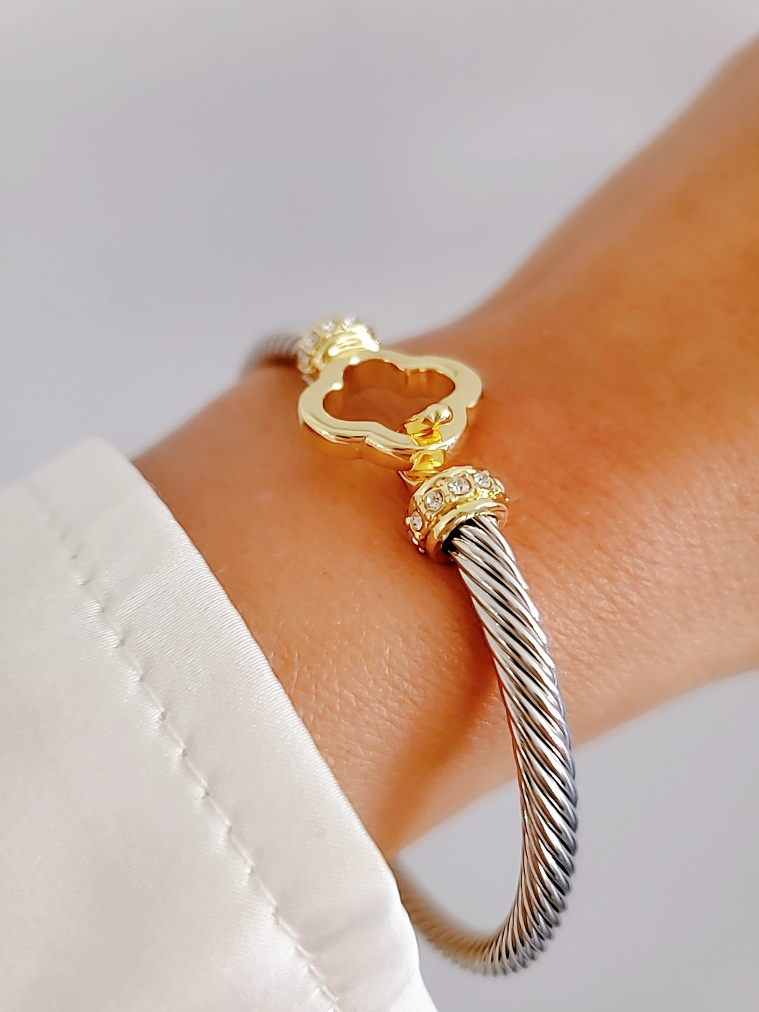 Elegant Clover Hook Bangle Bracelet made of stainless steel with sterling silver and 18K gold plating, featuring a unique clover hook design.