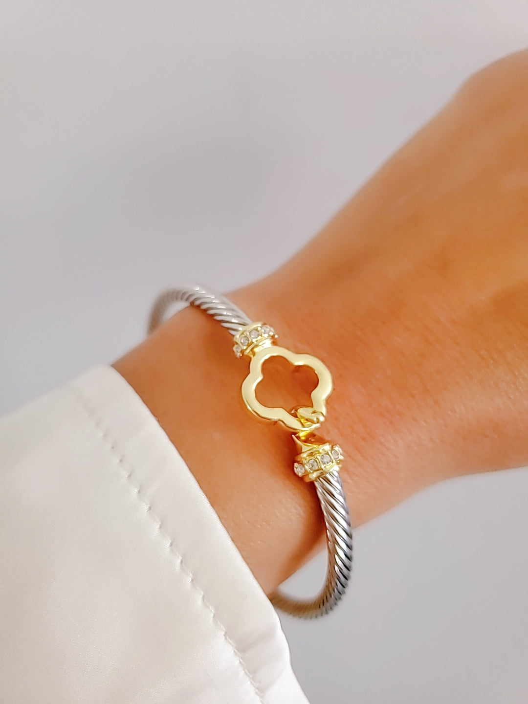 Elegant Clover Hook Bangle Bracelet made of stainless steel with sterling silver and 18K gold plating, featuring a unique clover hook design.