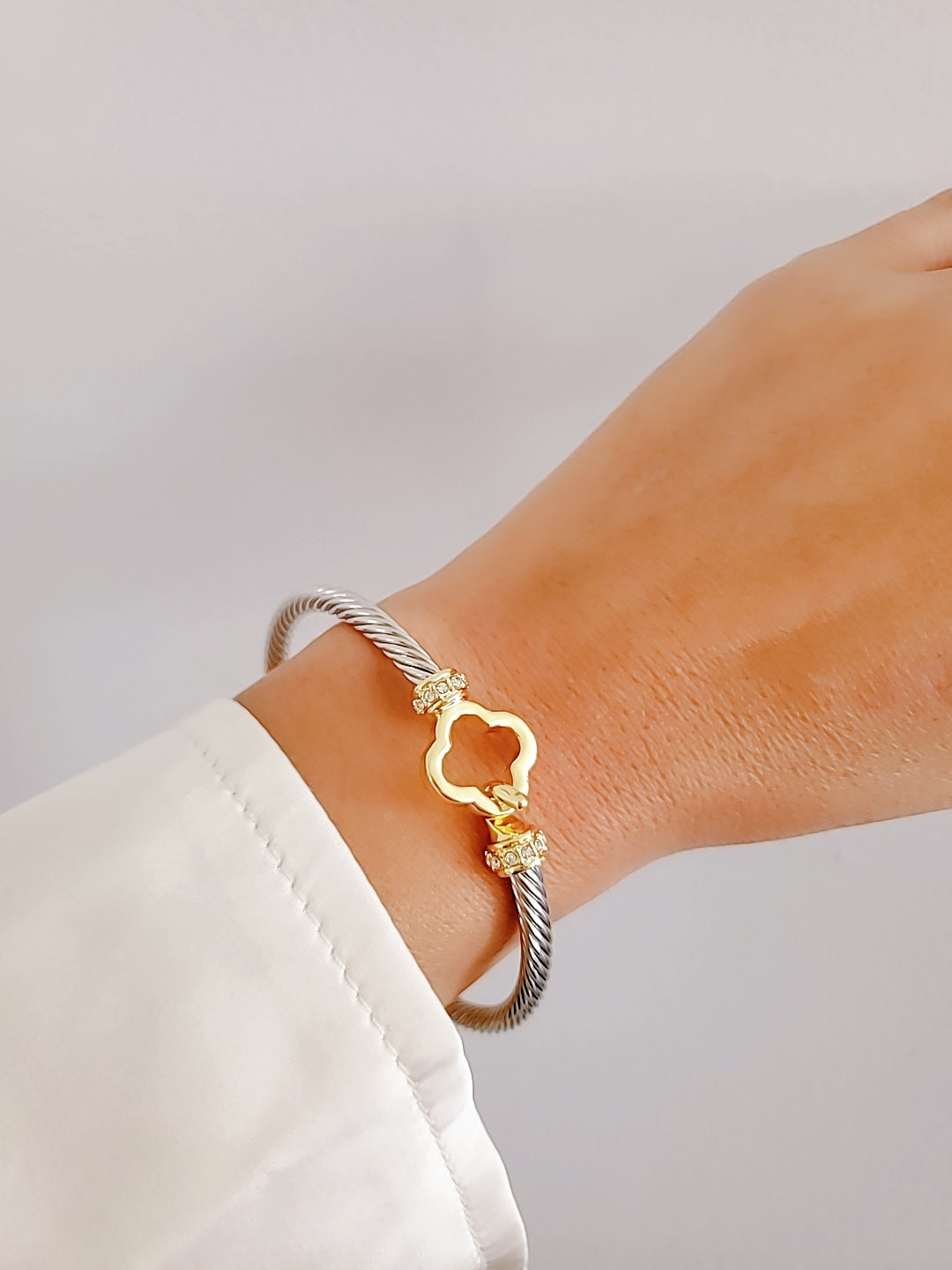 Elegant Clover Hook Bangle Bracelet made of stainless steel with sterling silver and 18K gold plating, featuring a unique clover hook design.