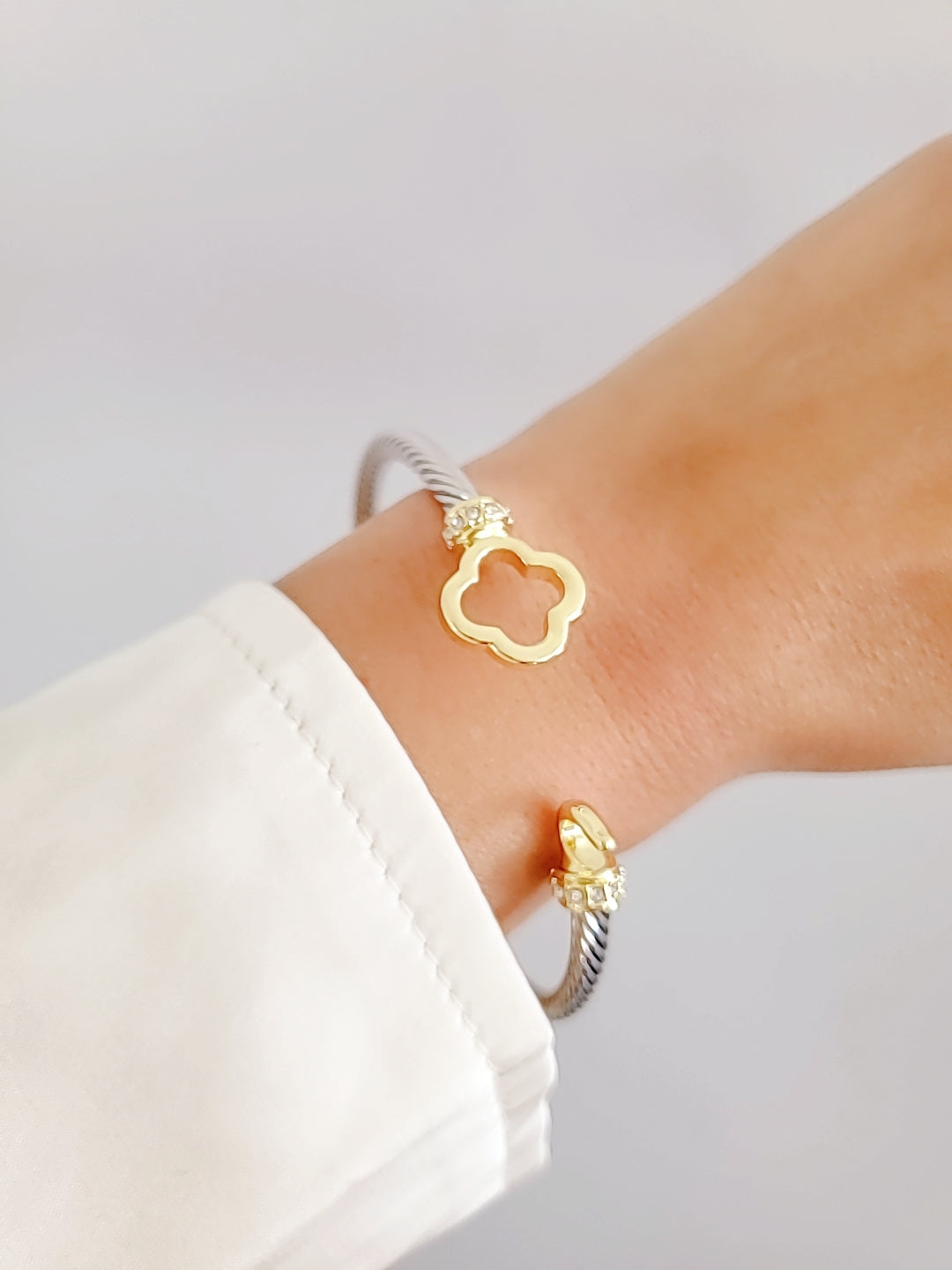 Elegant Clover Hook Bangle Bracelet made of stainless steel with sterling silver and 18K gold plating, featuring a unique clover hook design.