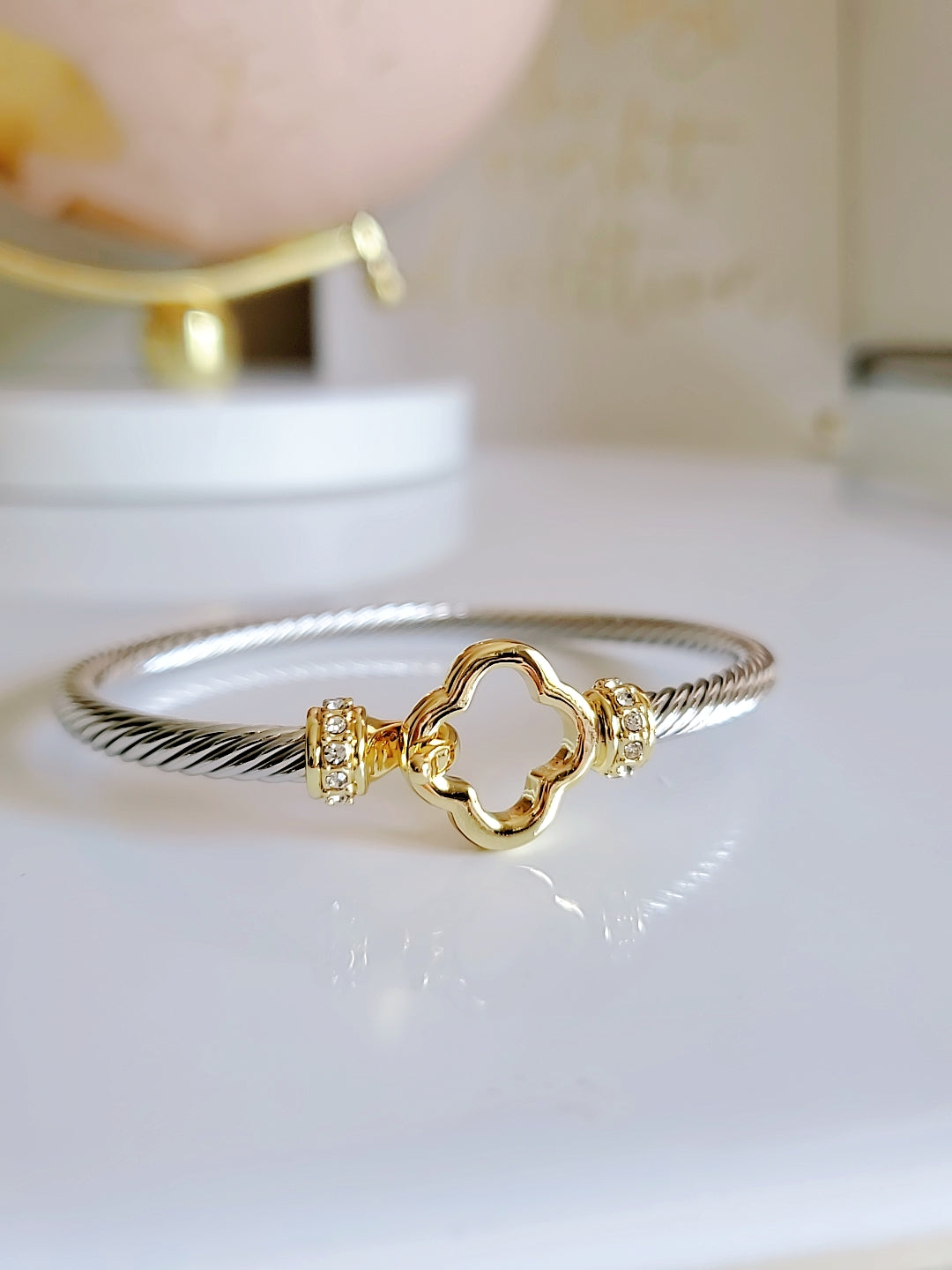 Elegant Clover Hook Bangle Bracelet made of stainless steel with sterling silver and 18K gold plating, featuring a unique clover hook design.