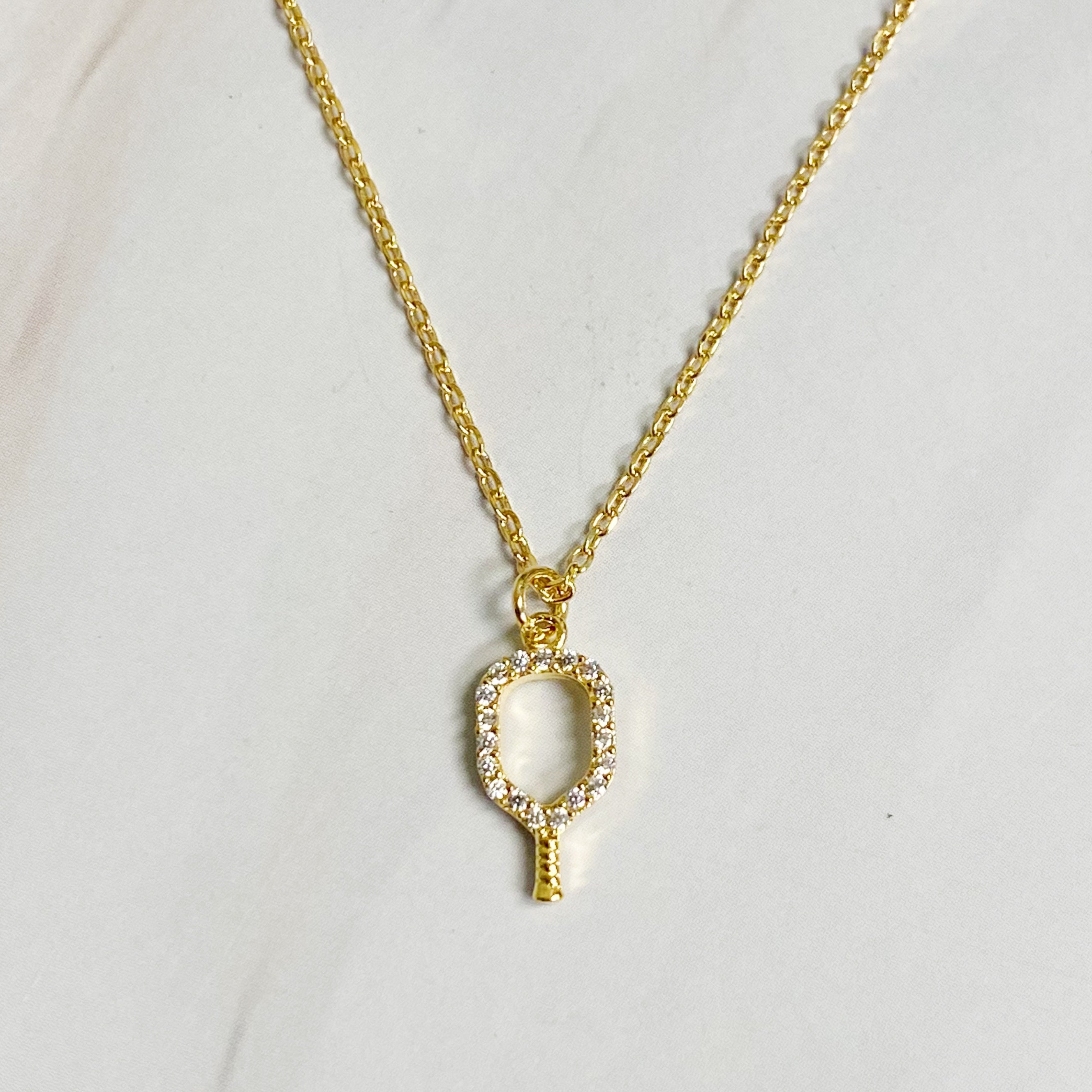 A delicate gold plated brass necklace featuring a pickleball racket outline, perfect for pickleball enthusiasts.