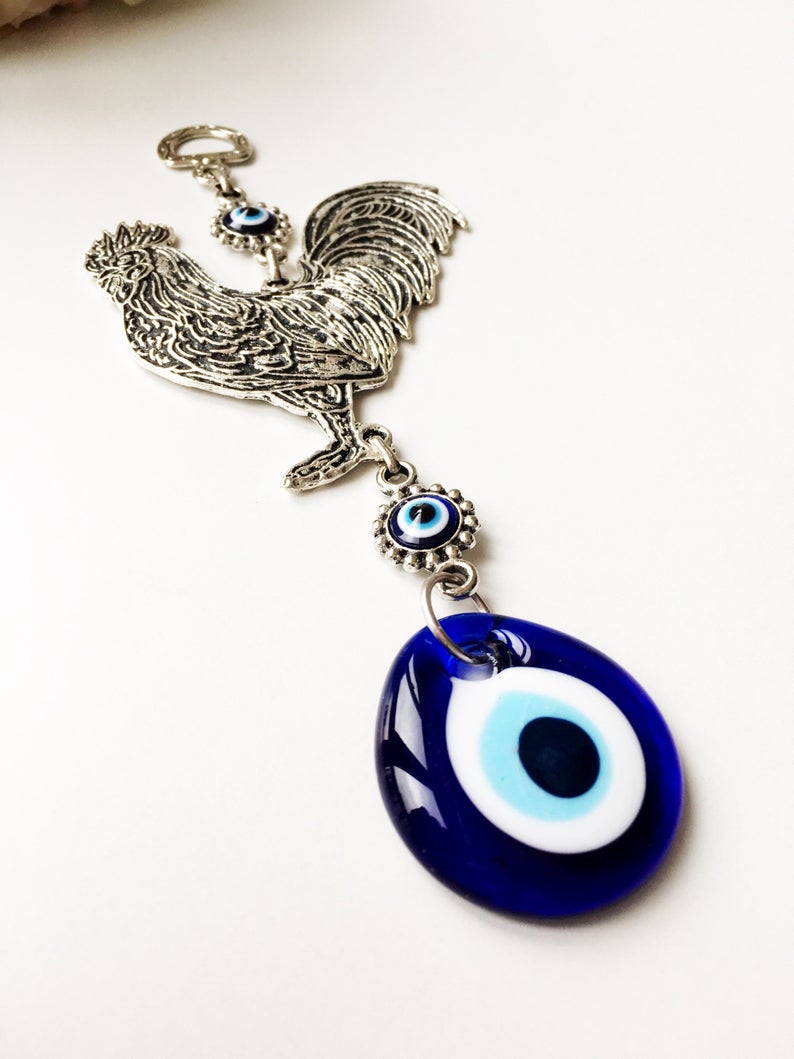 Handmade Cock Evil Eye Wall Hanging featuring a vibrant evil eye bead and metal charm, measuring 20cm in length.