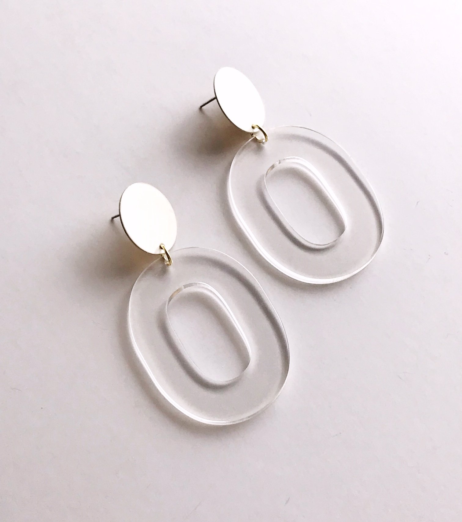 Coco earrings featuring large ivory acetate hoops and enameled brass discs, showcasing a stylish and lightweight design.