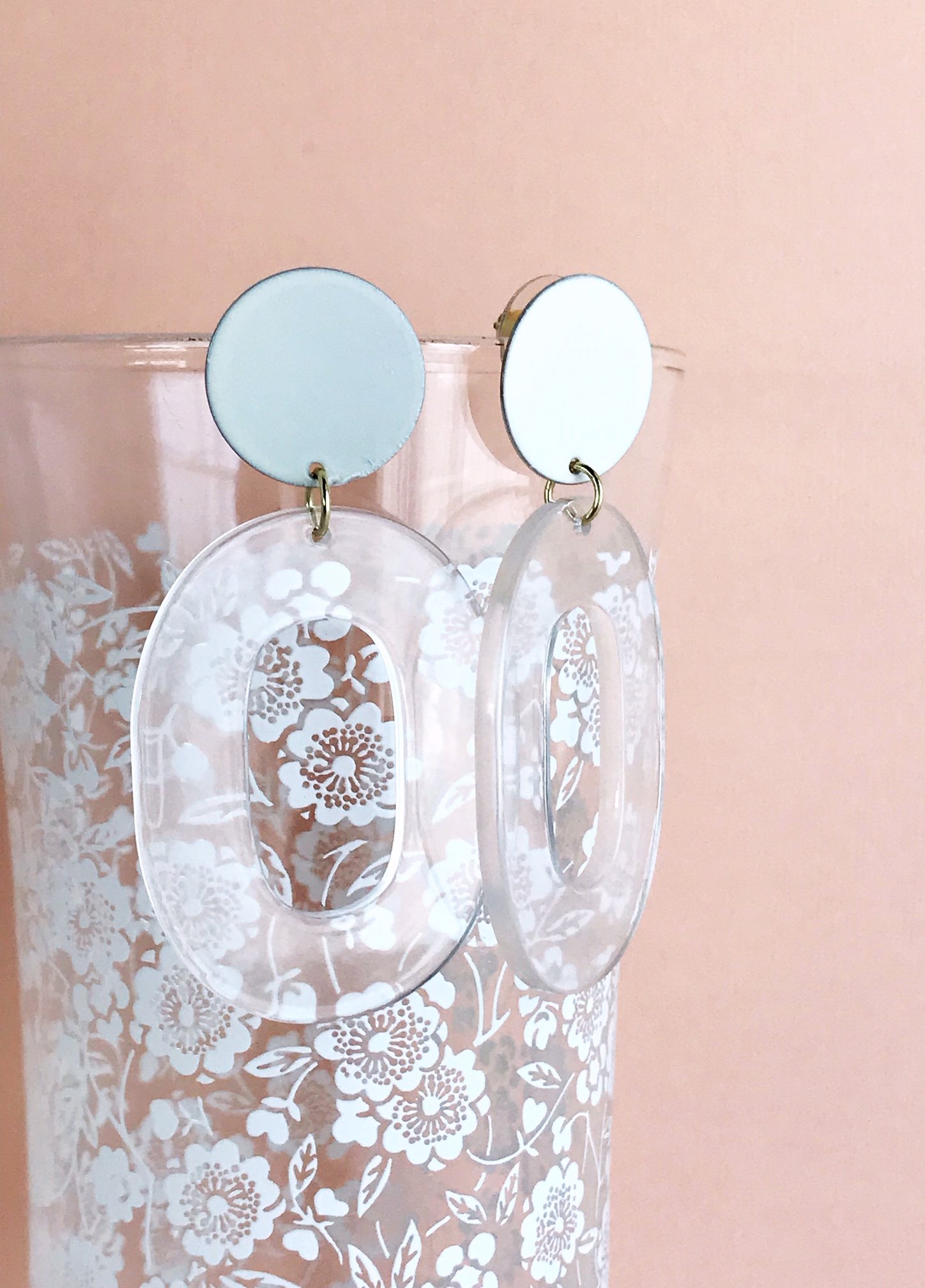 Coco earrings featuring large ivory acetate hoops and enameled brass discs, showcasing a stylish and lightweight design.