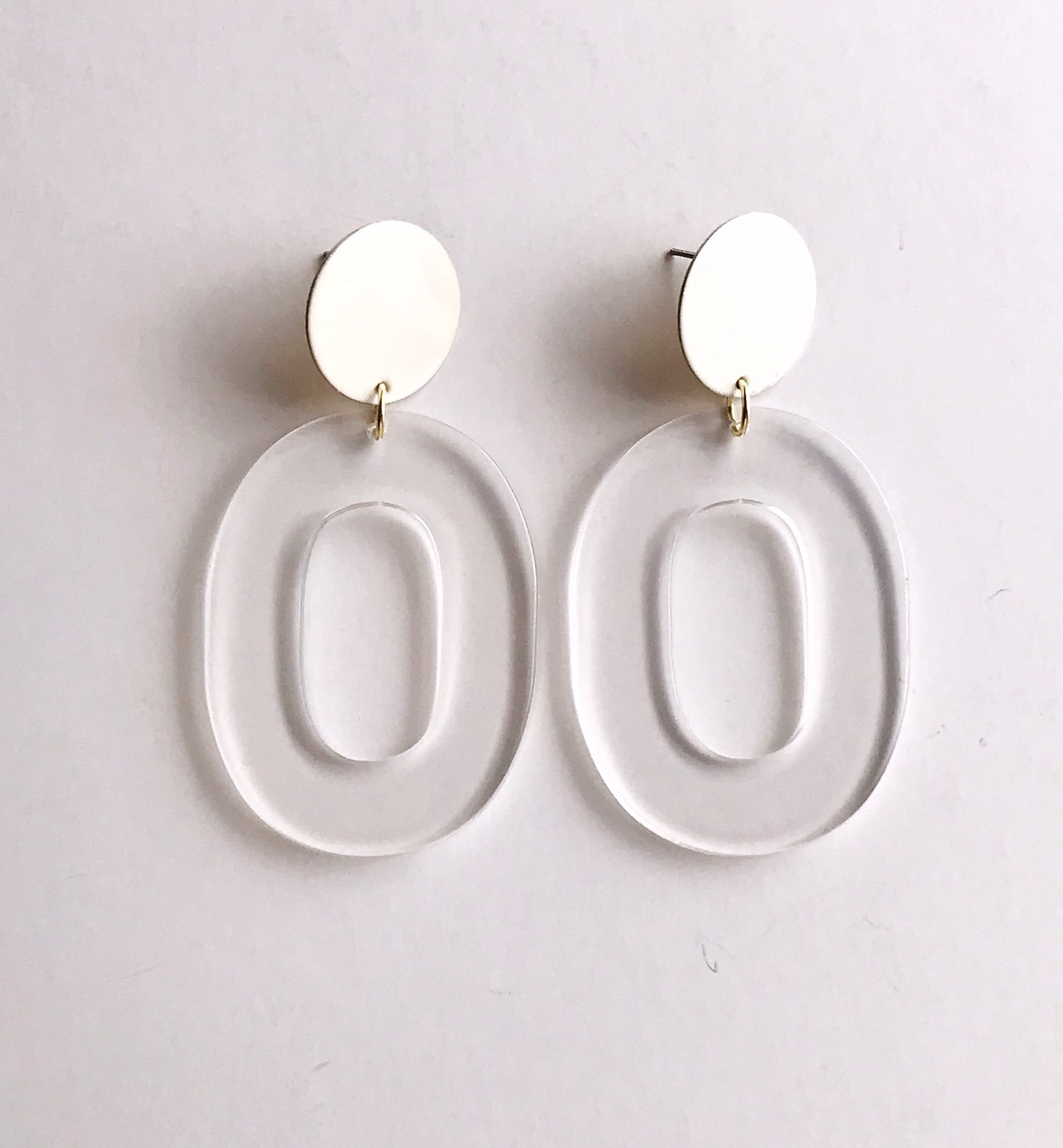 Coco earrings featuring large ivory acetate hoops and enameled brass discs, showcasing a stylish and lightweight design.