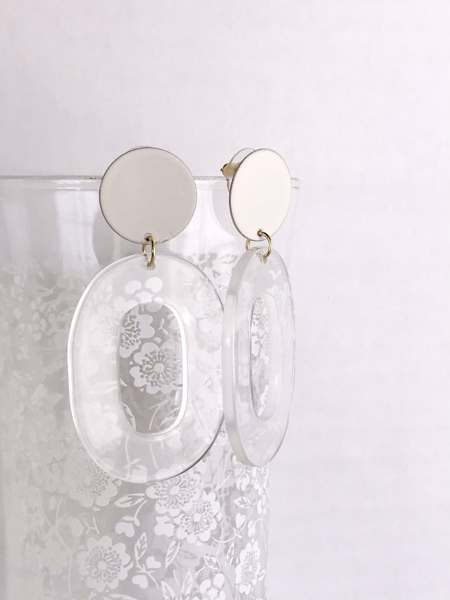 Coco earrings featuring large ivory acetate hoops and enameled brass discs, showcasing a stylish and lightweight design.