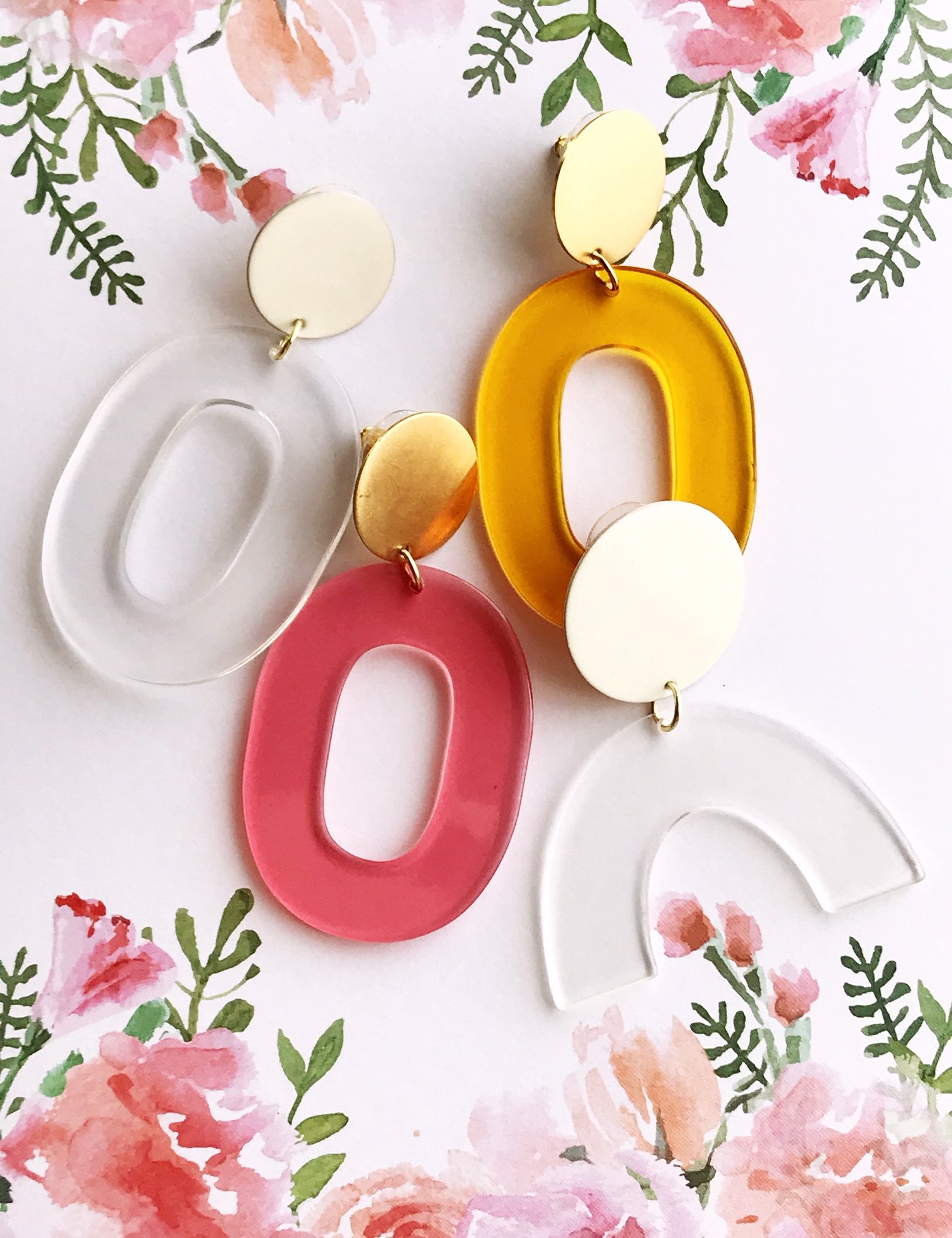 Coco earrings featuring large ivory acetate hoops and enameled brass discs, showcasing a stylish and lightweight design.