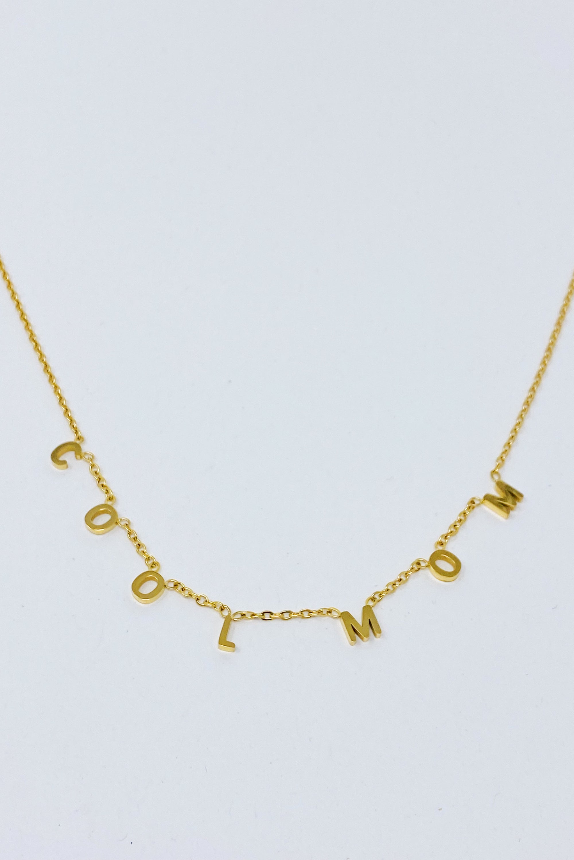 A stylish Cool Mom Necklace featuring high-polished letters on a dainty chain, perfect for fashionable mothers.