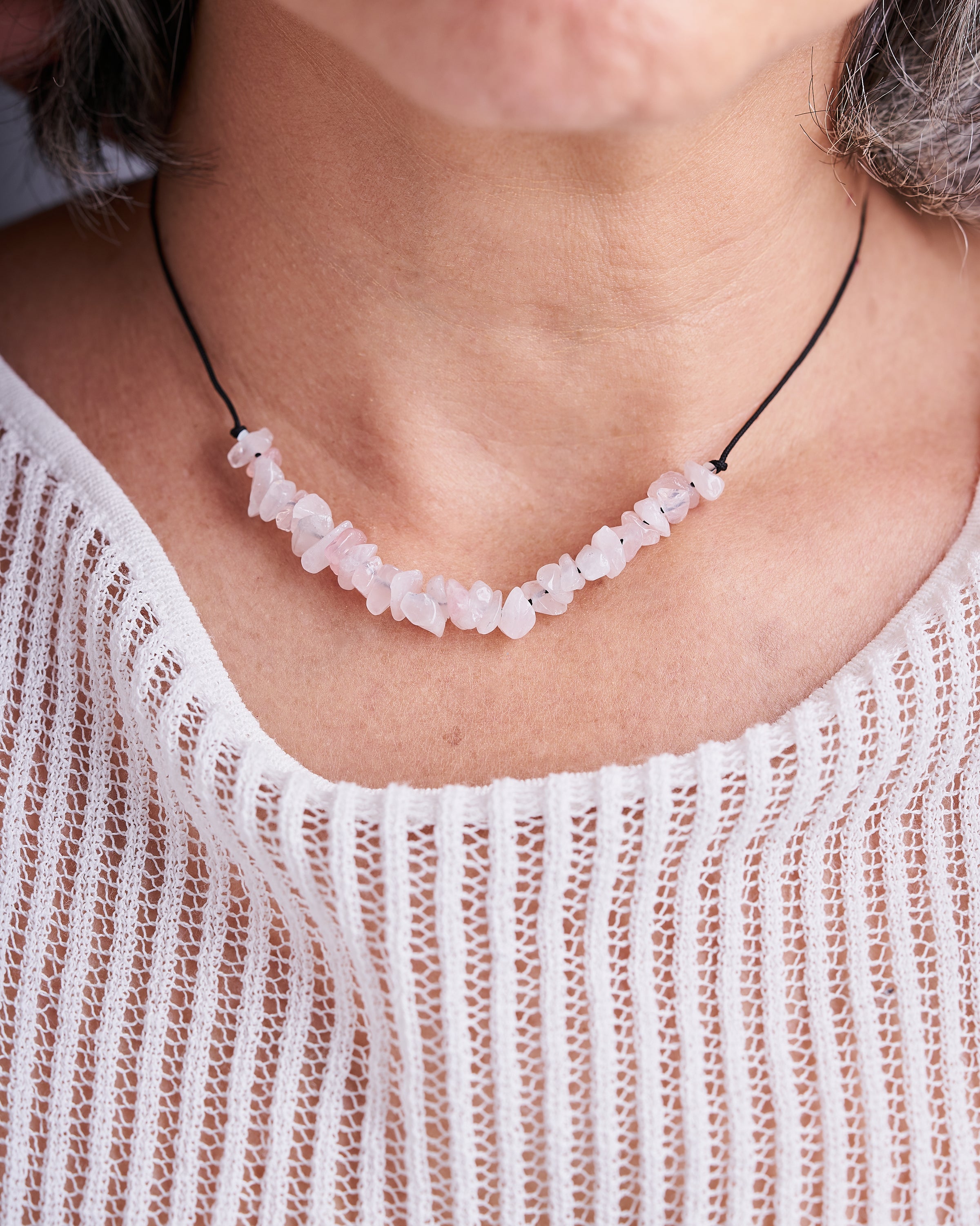 Collar hecho a mano con piedras de cuarzo rosa y mini cubos de hematita, presentado en una tarjeta elegante.