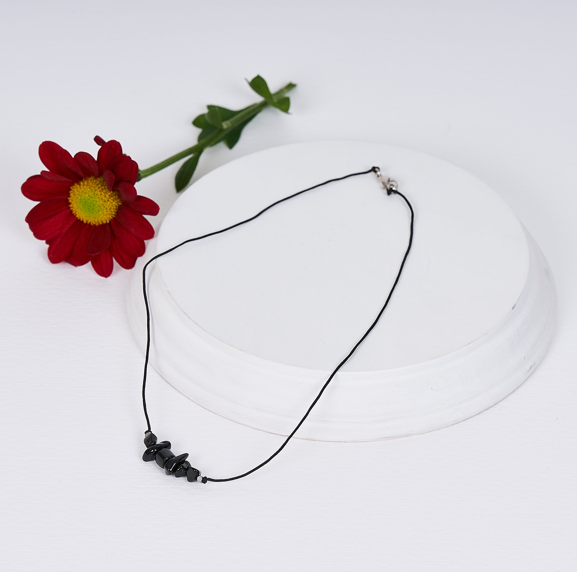 Collar de obsidiana natural hecho a mano, con colgante delicado y tarjeta descriptiva, ideal para protección y energía positiva.