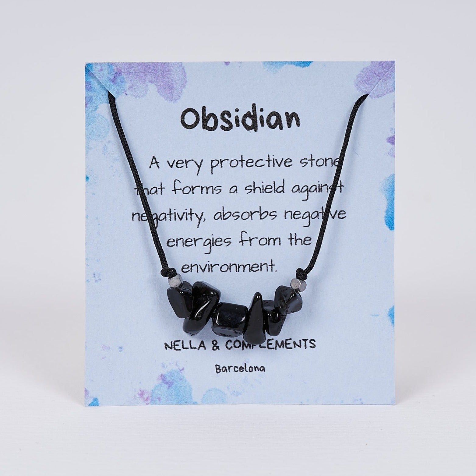 Collar de obsidiana natural hecho a mano, con colgante delicado y tarjeta descriptiva, ideal para protección y energía positiva.