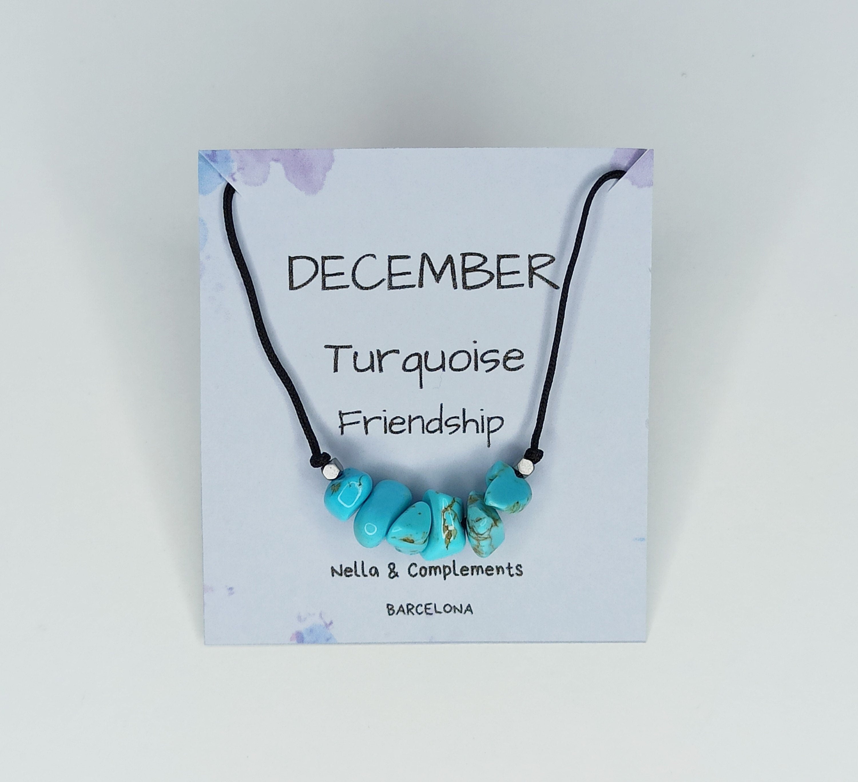 Collar hecho a mano con piedras de turquesa, símbolo de la piedra natal de diciembre, presentado en una tarjeta decorativa.