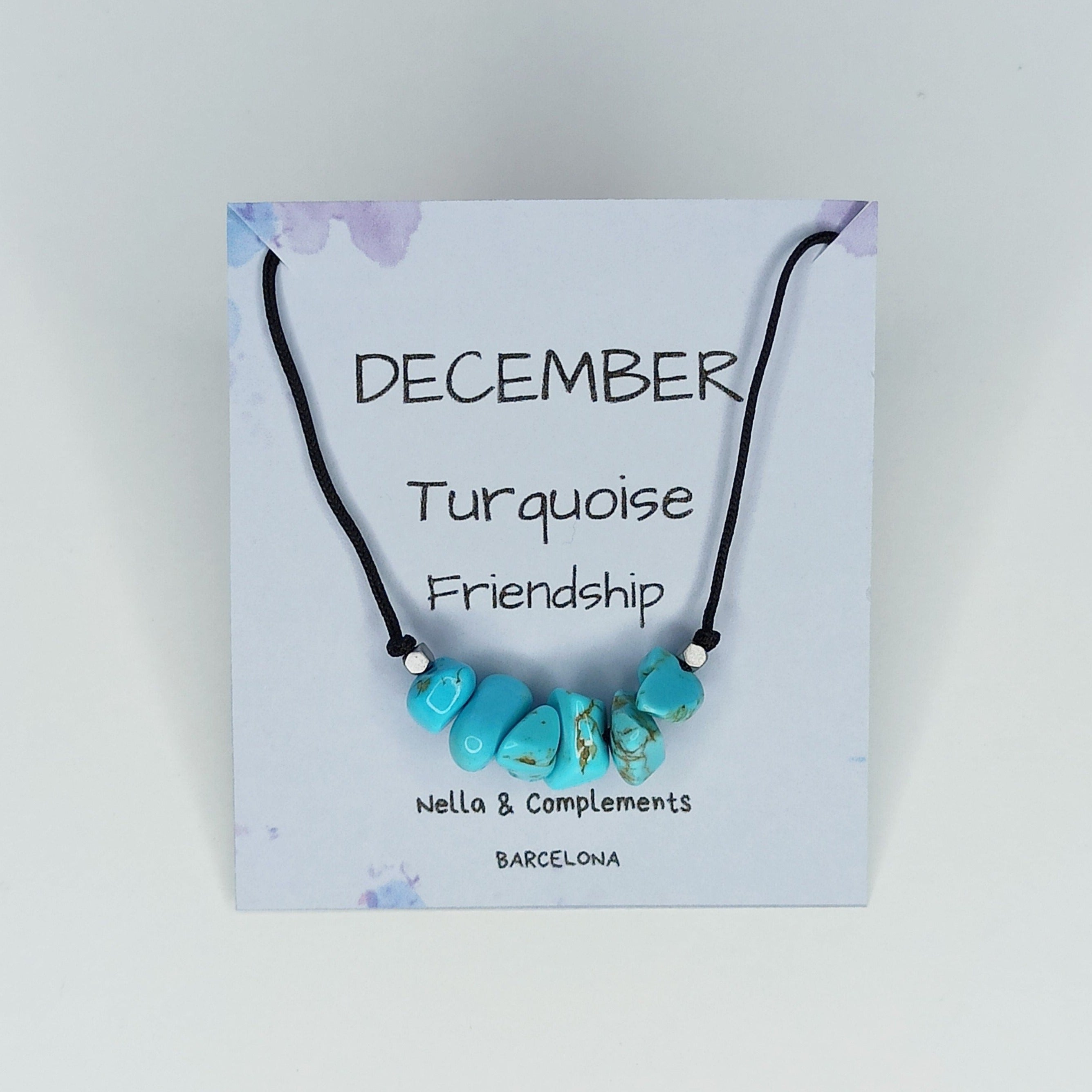 Collar hecho a mano con piedras de turquesa, símbolo de la piedra natal de diciembre, presentado en una tarjeta decorativa.