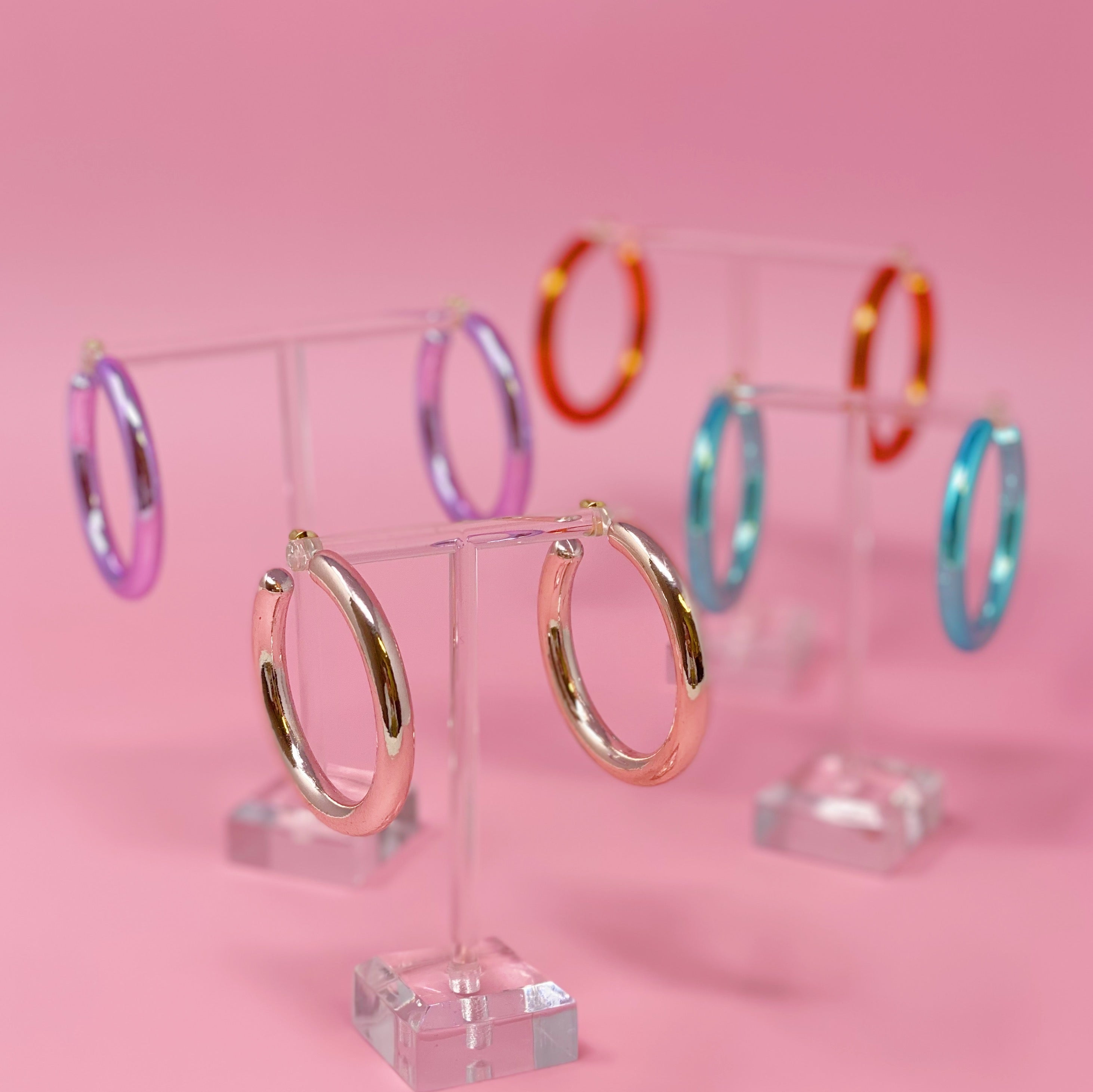 A pair of colorful metallic finish tube hoop earrings, showcasing vibrant hues and a lightweight design, perfect for everyday wear.