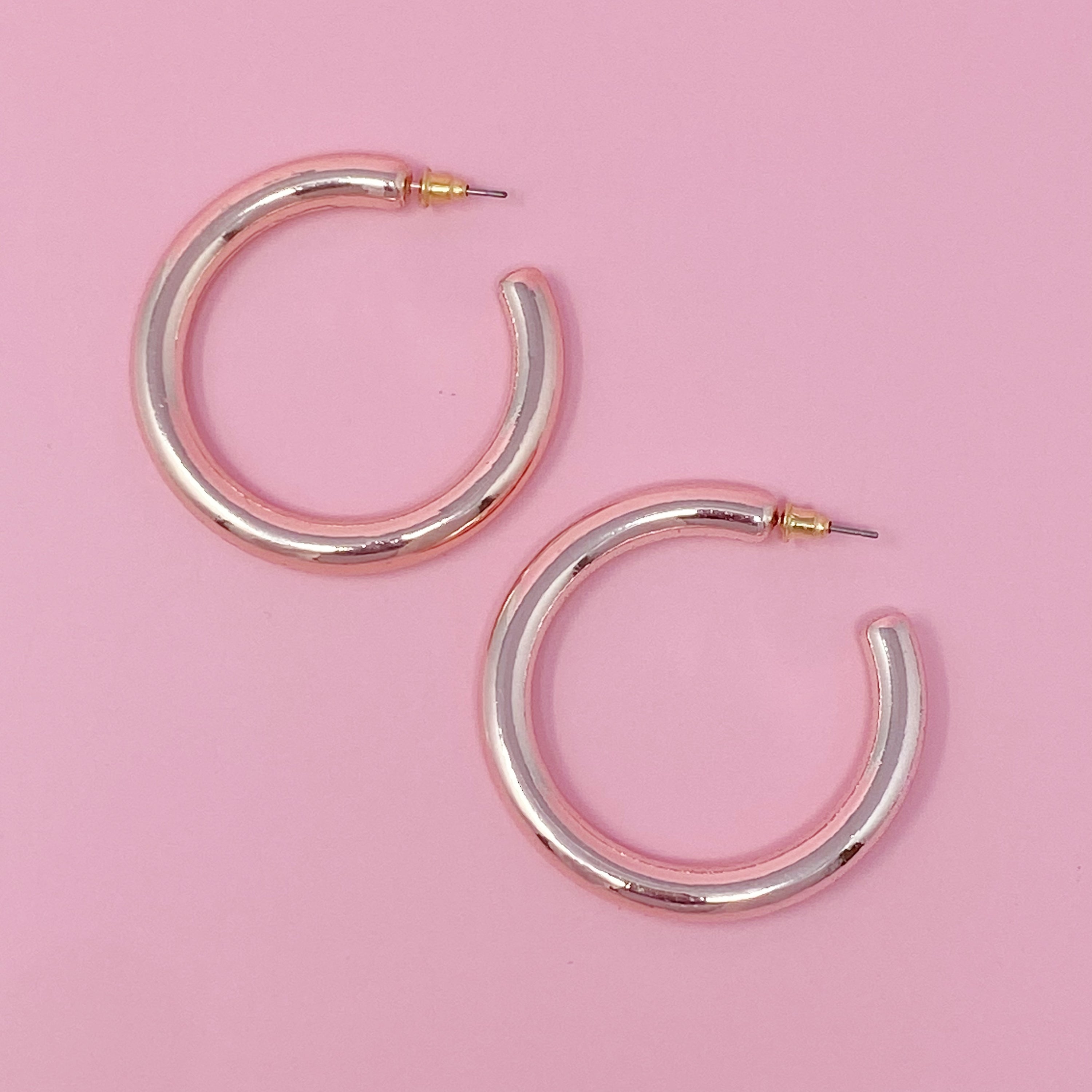 A pair of colorful metallic finish tube hoop earrings, showcasing vibrant hues and a lightweight design, perfect for everyday wear.