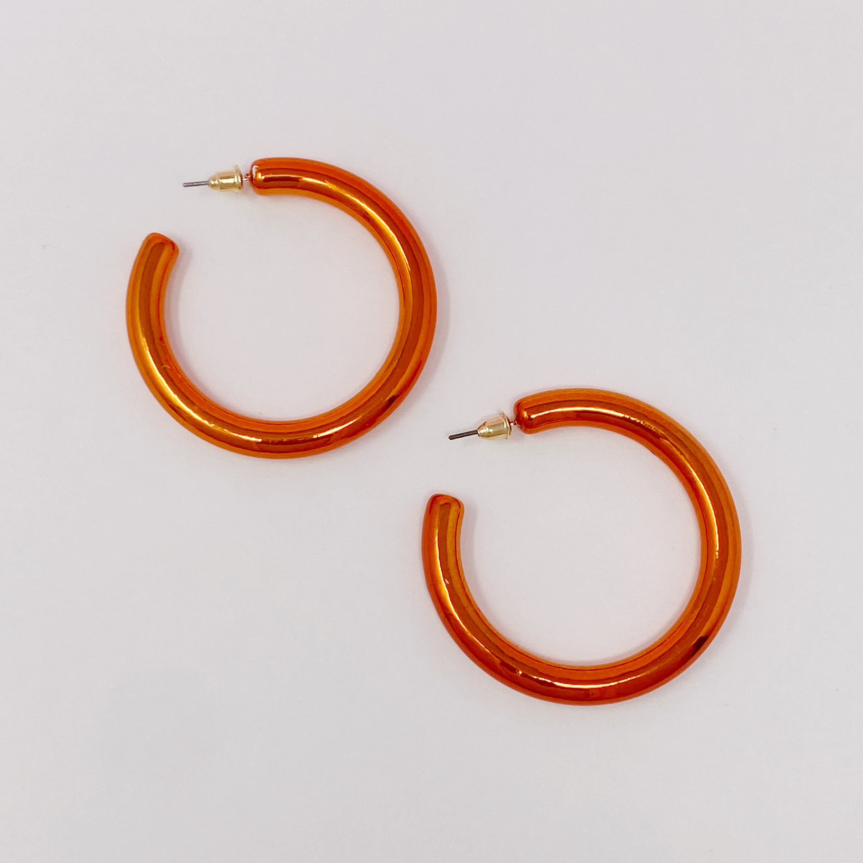 A pair of colorful metallic finish tube hoop earrings, showcasing vibrant hues and a lightweight design, perfect for everyday wear.