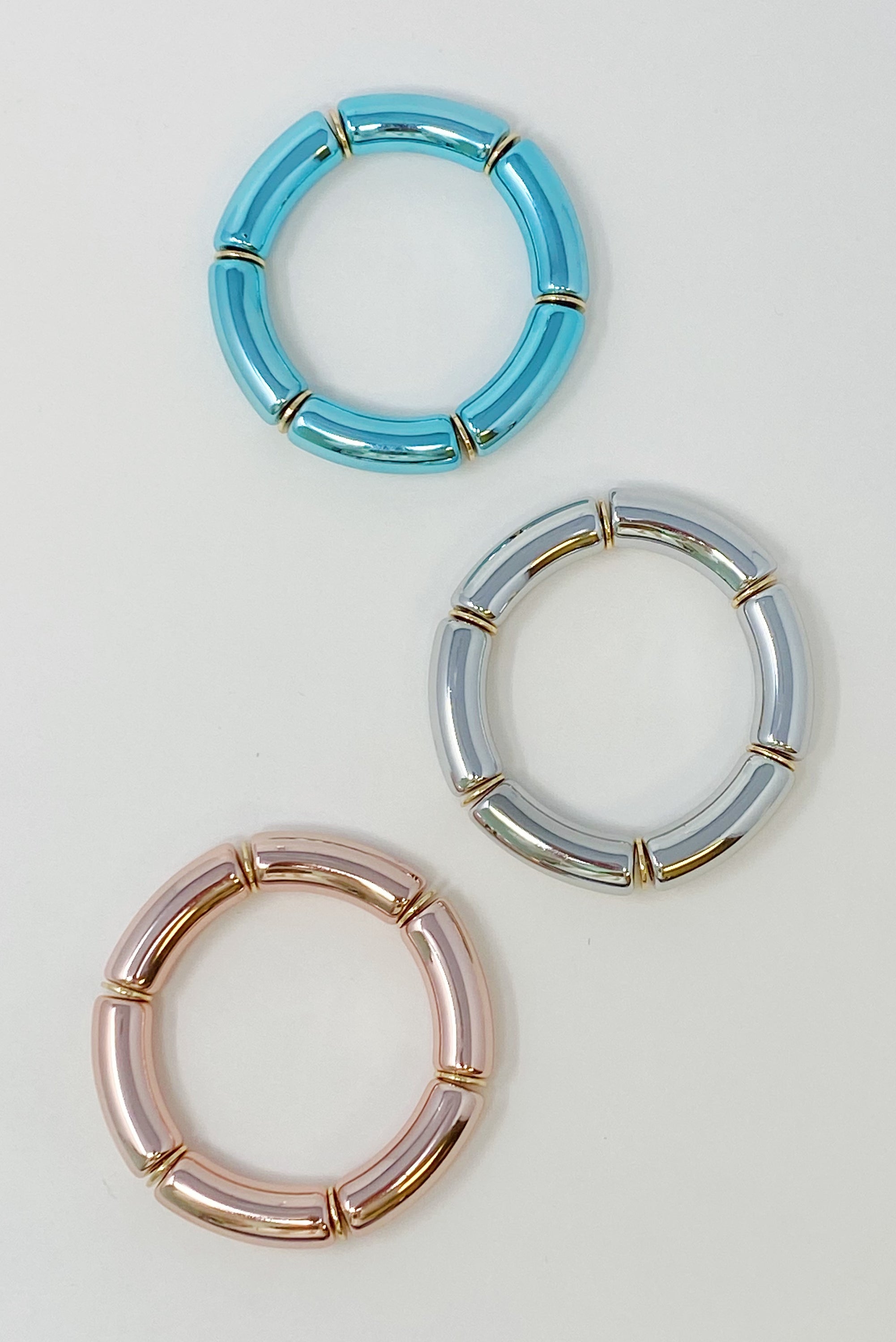 A colorful tube stretch bracelet made of gold plated brass, featuring vibrant tubes in a lightweight design.