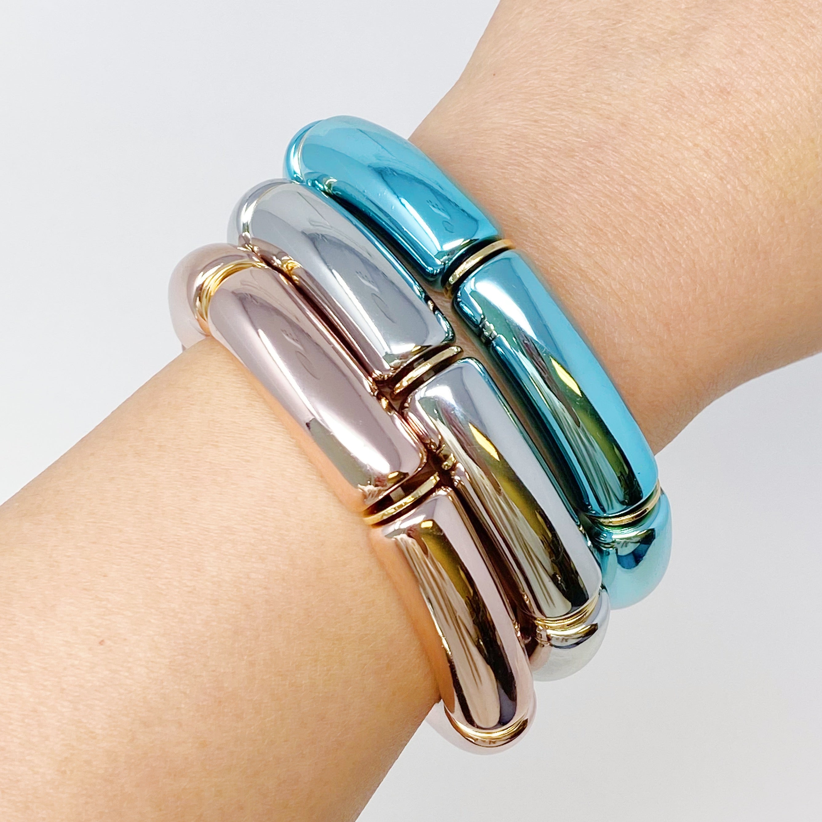 A colorful tube stretch bracelet made of gold plated brass, featuring vibrant tubes in a lightweight design.