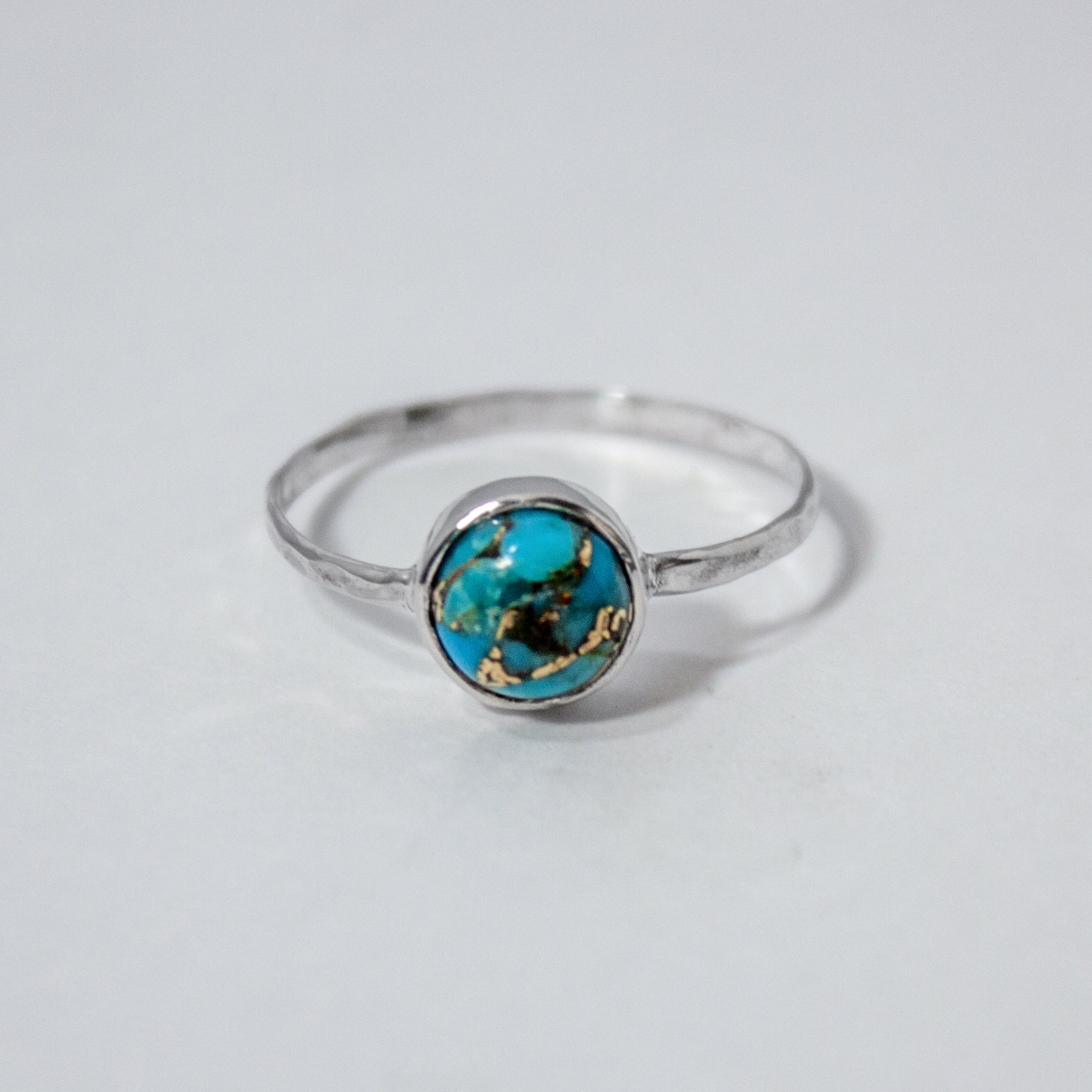 Copper Turquoise Bezel Sterling Silver Ring featuring a 6mm turquoise stone set in a hammered sterling silver band.