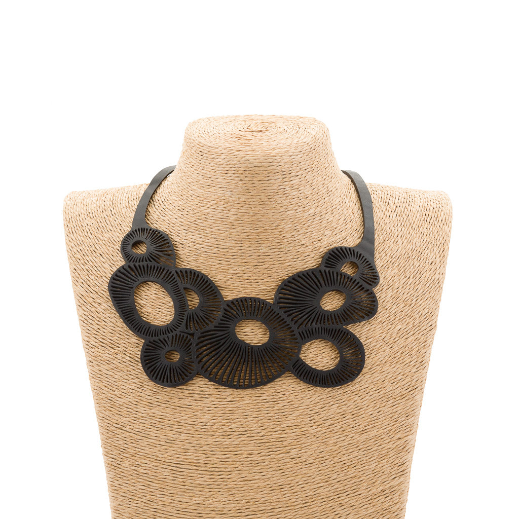 A stylish Coral Eco Friendly Rubber Necklace made from recycled materials, showcasing its unique design and craftsmanship.