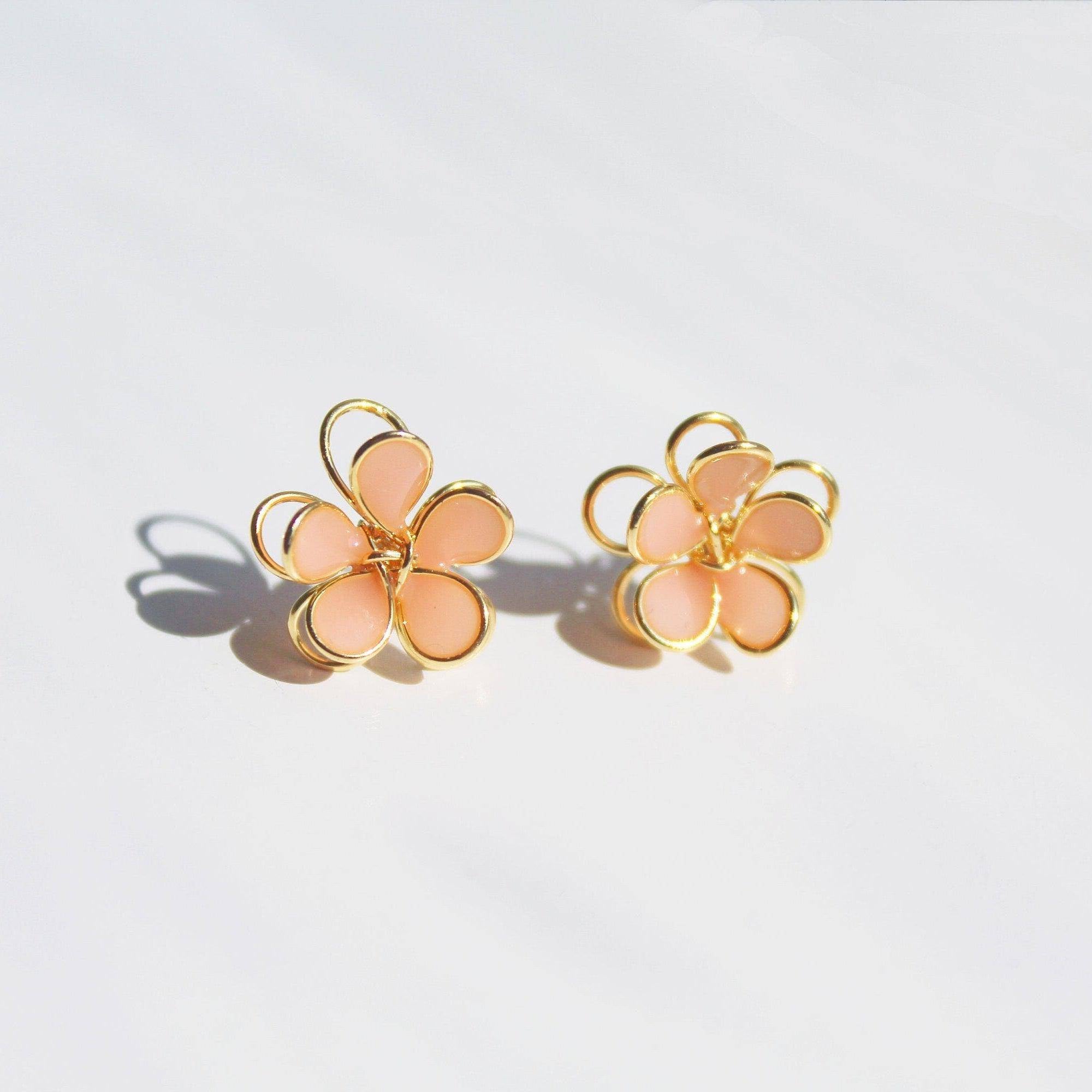 A pair of handmade orange cosmos flower earrings featuring double-layer design in gold wire and sterling silver studs, elegantly displayed.