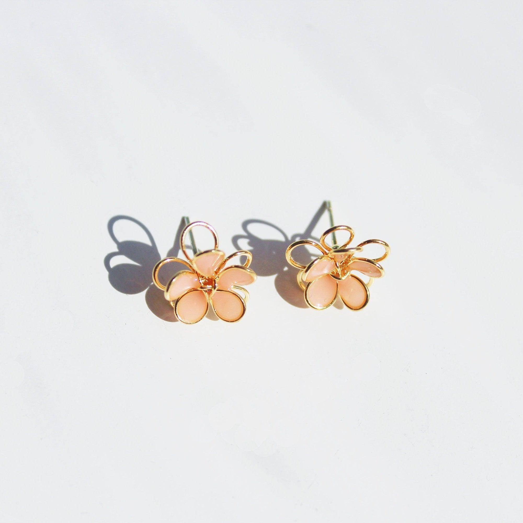 A pair of handmade orange cosmos flower earrings featuring double-layer design in gold wire and sterling silver studs, elegantly displayed.