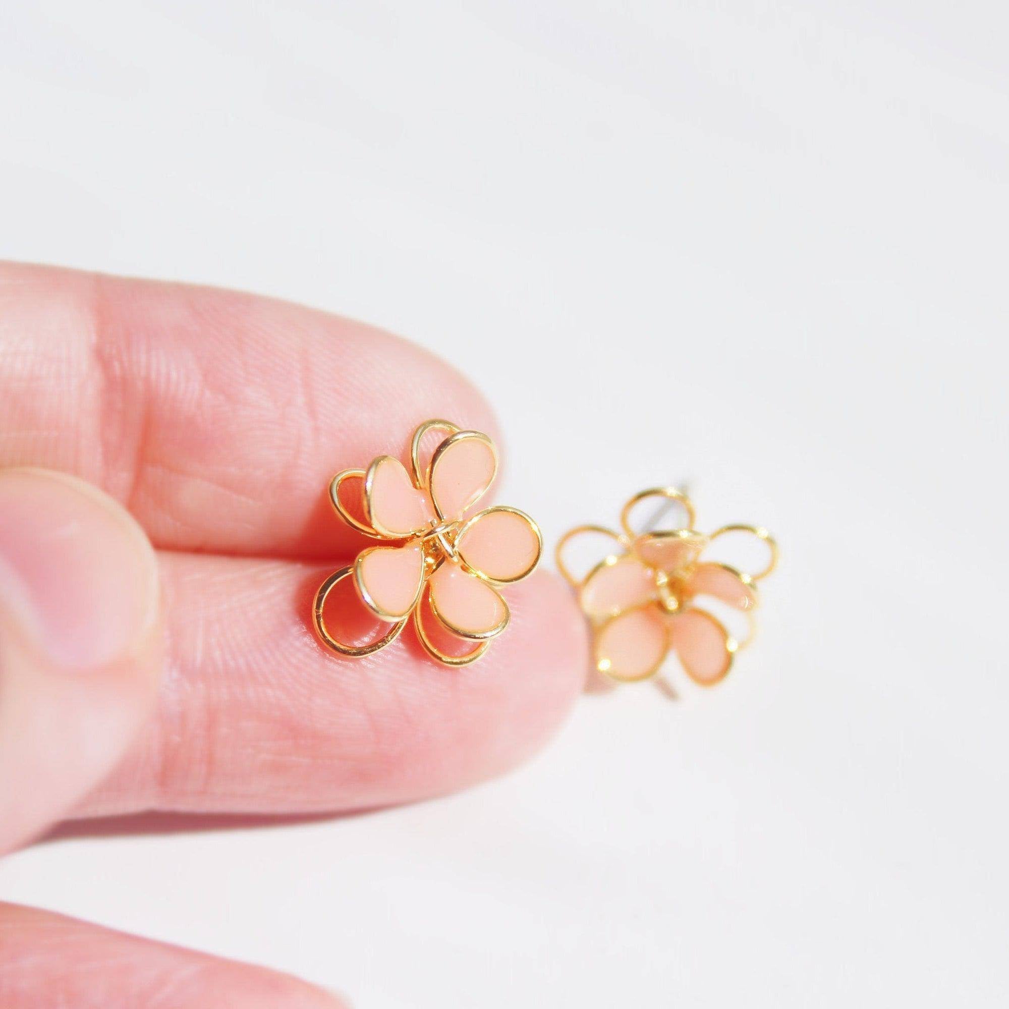 A pair of handmade orange cosmos flower earrings featuring double-layer design in gold wire and sterling silver studs, elegantly displayed.