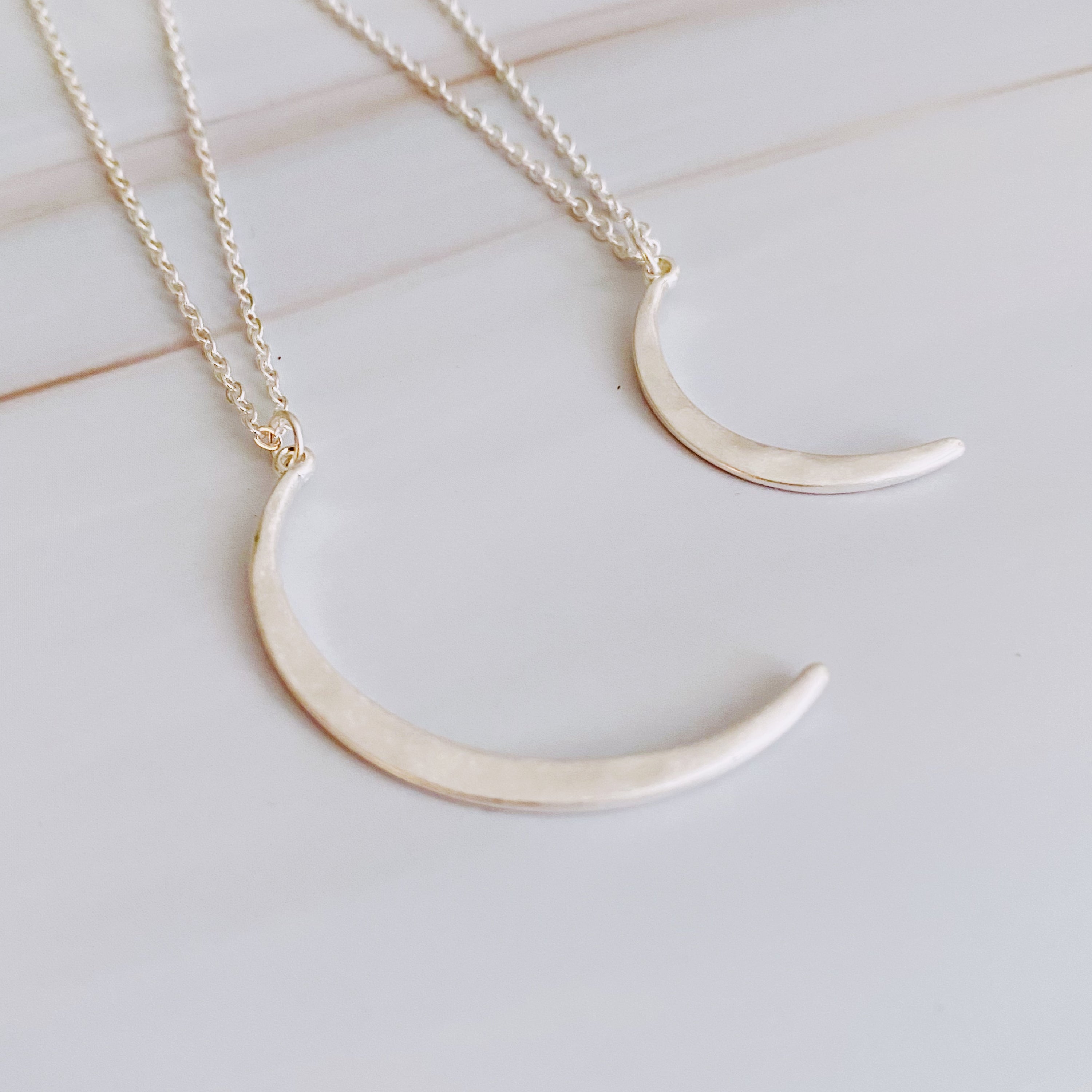 Crescent Duo Necklace Set of 2 featuring two crescent pendants in different sizes on adjustable chains.