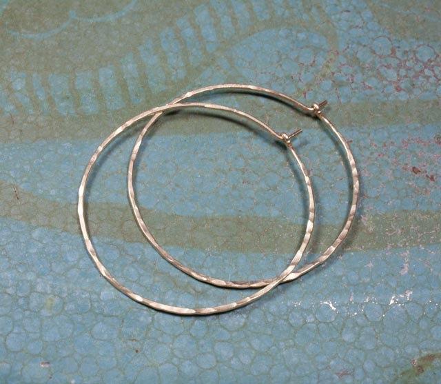 Elegant crescent moon hoop earrings in various sizes and finishes, showcasing a hammered texture and organic curves.