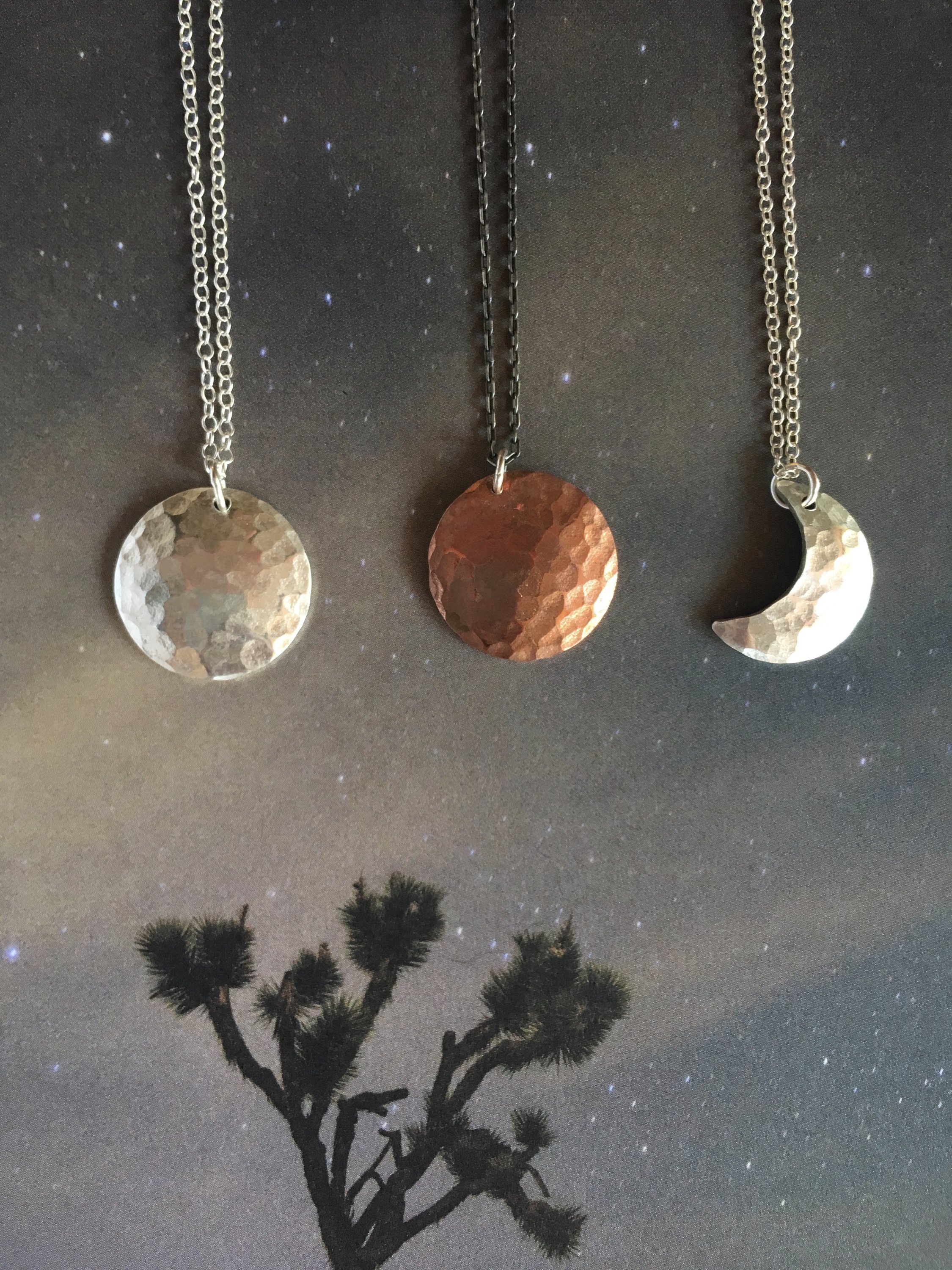 A beautifully handcrafted crescent moon necklace with a hammered texture, showcasing its unique design and sustainable materials.