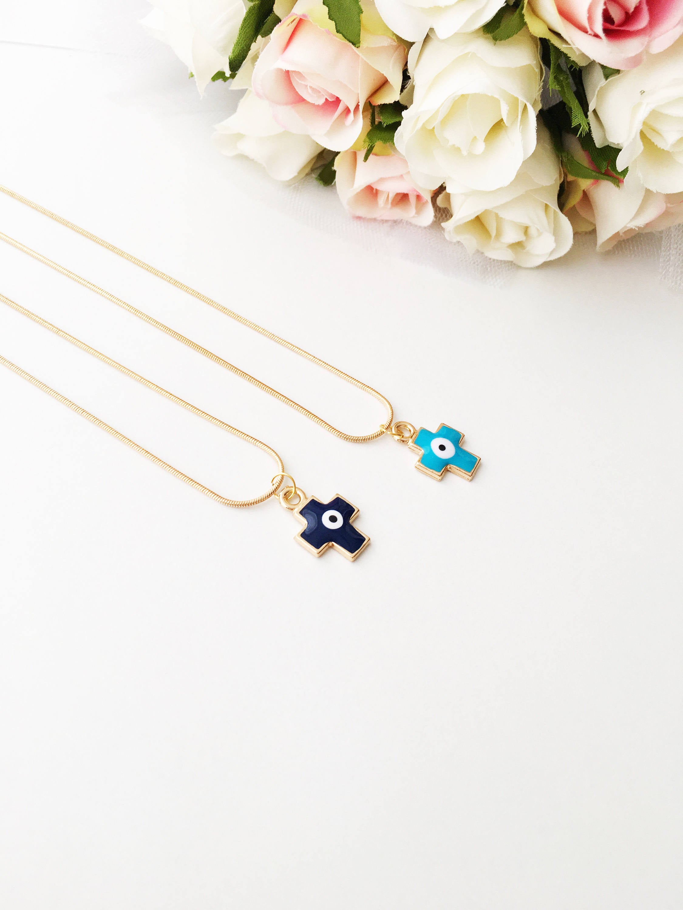 Handmade Cross Evil Eye Necklace featuring blue and red charm on a gold plated chain, symbolizing protection and spirituality.