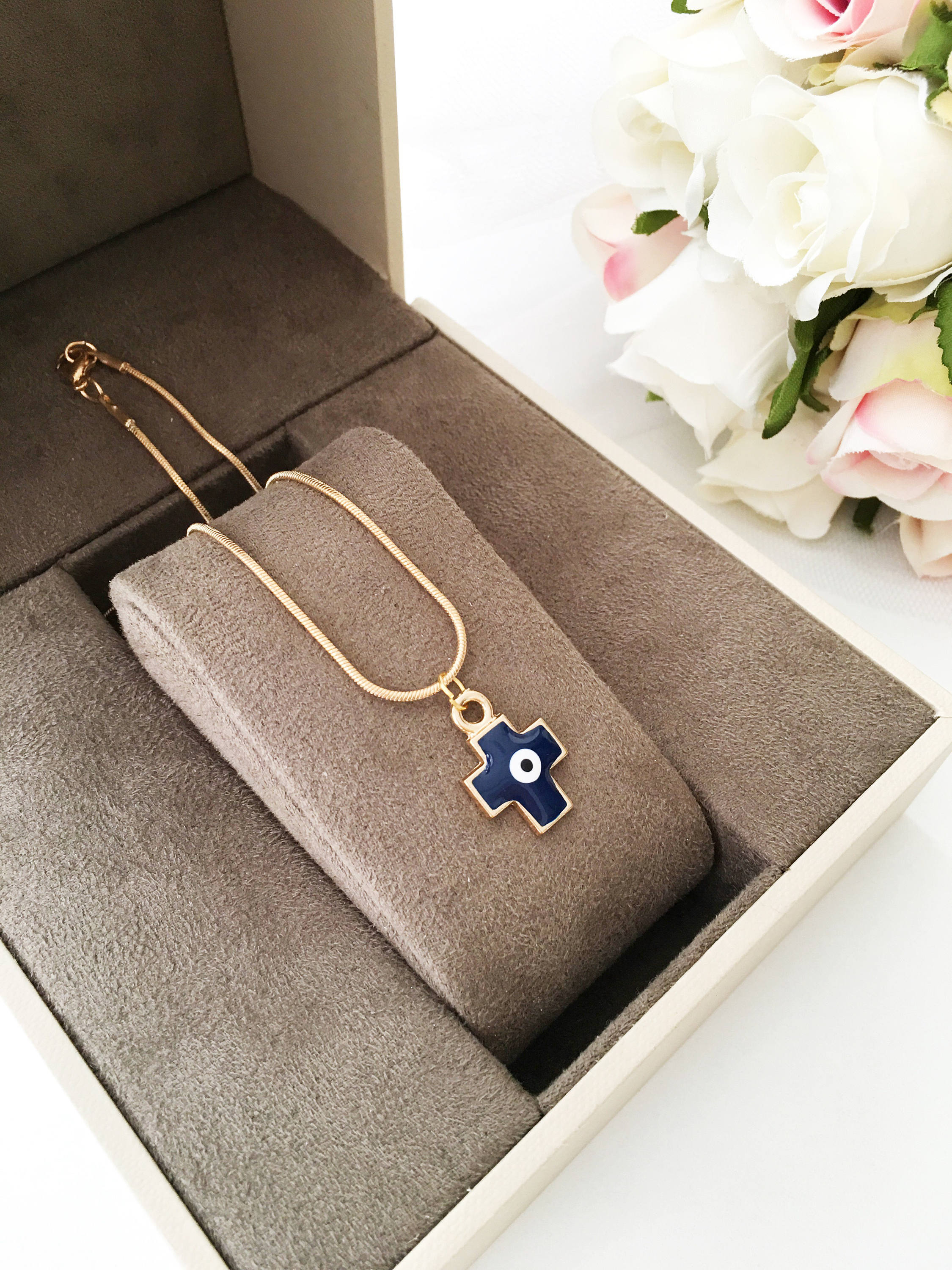 Handmade Cross Evil Eye Necklace featuring blue and red charm on a gold plated chain, symbolizing protection and spirituality.