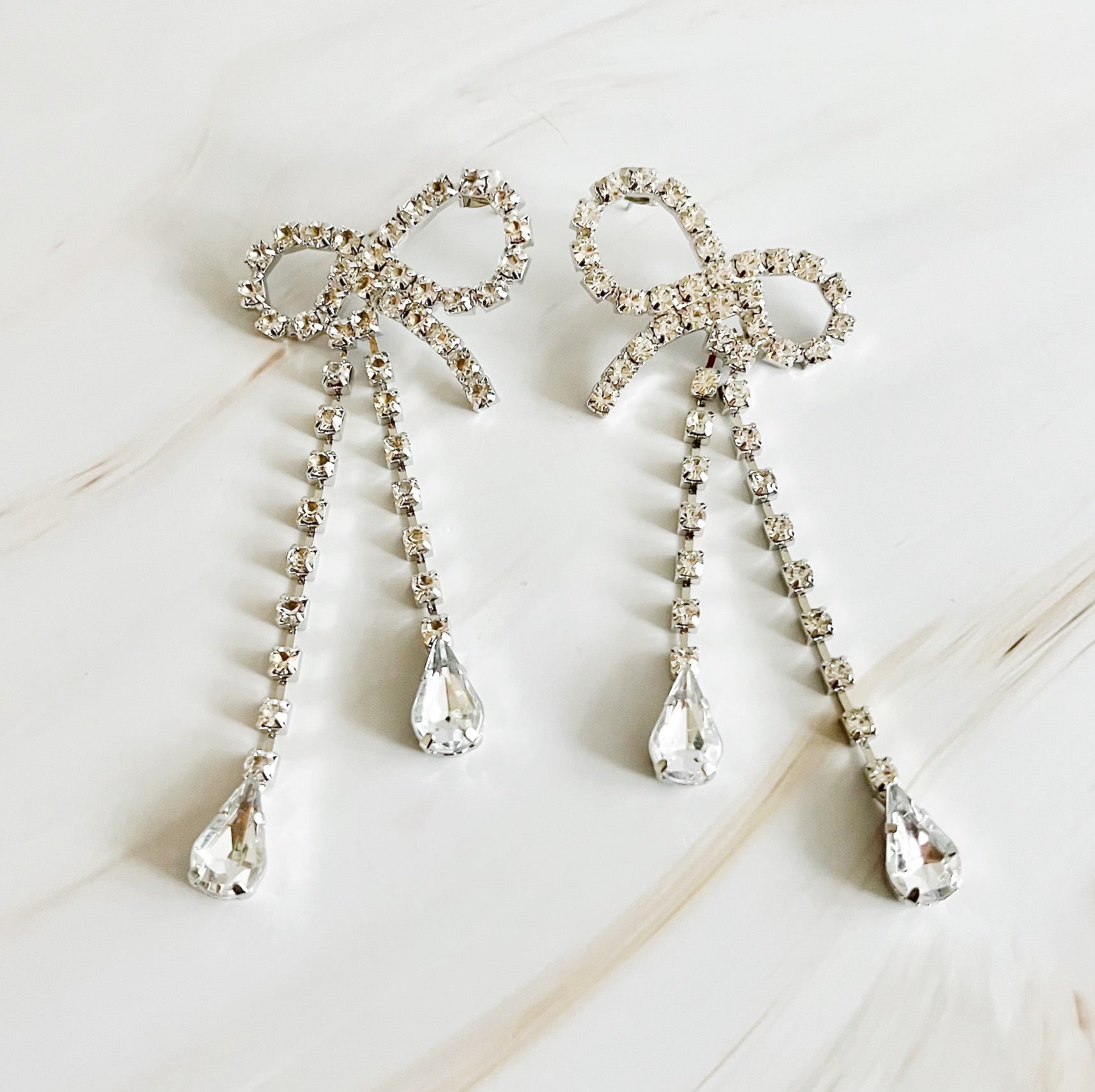 Elegant Crystal Bow Drop Earrings featuring sparkling glass stones and a rhodium plated finish, perfect for any occasion.