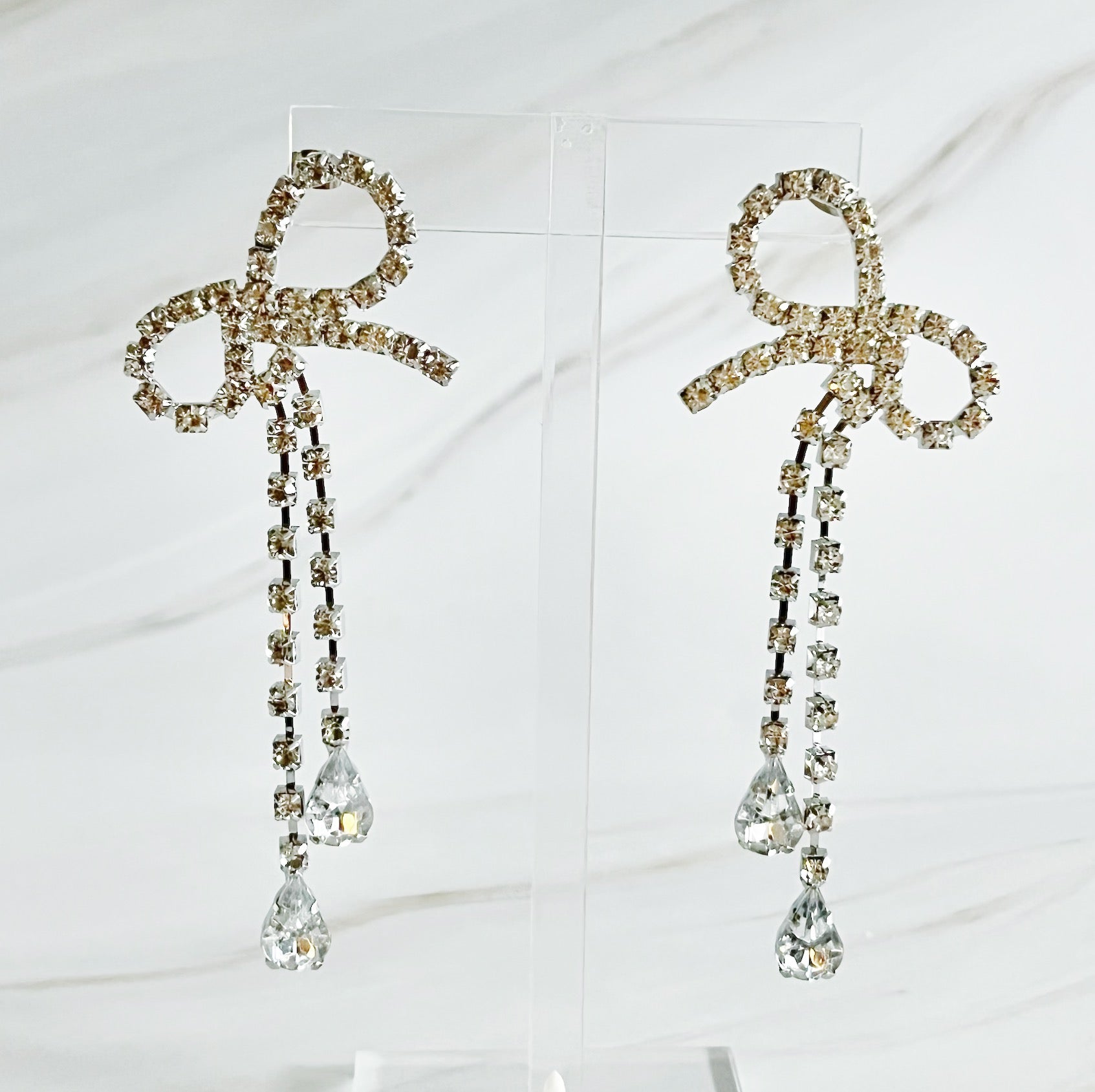 Elegant Crystal Bow Drop Earrings featuring sparkling glass stones and a rhodium plated finish, perfect for any occasion.