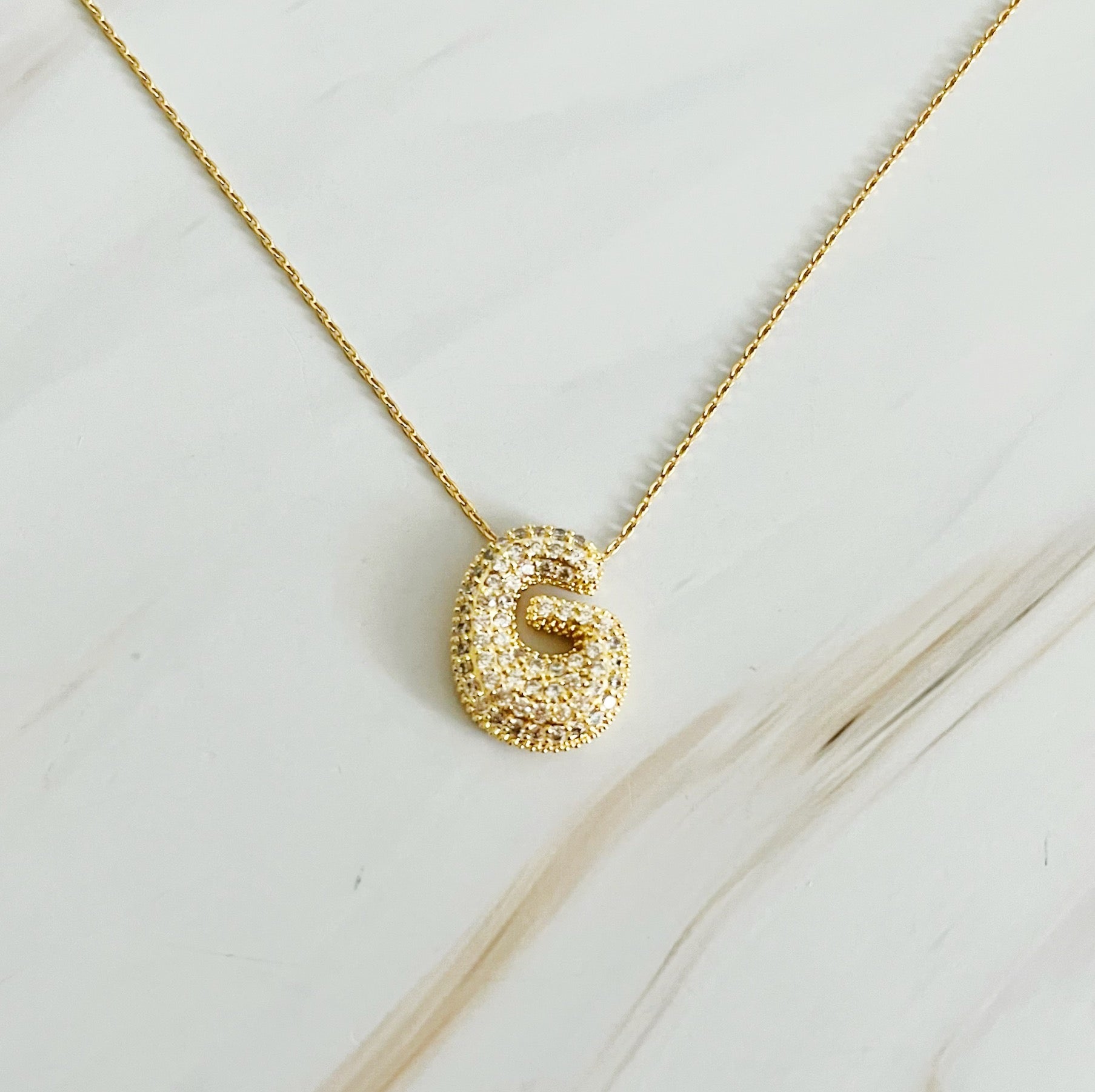 Elegant Crystal Bubble Initial Necklace in 18k gold plating with customizable charm.