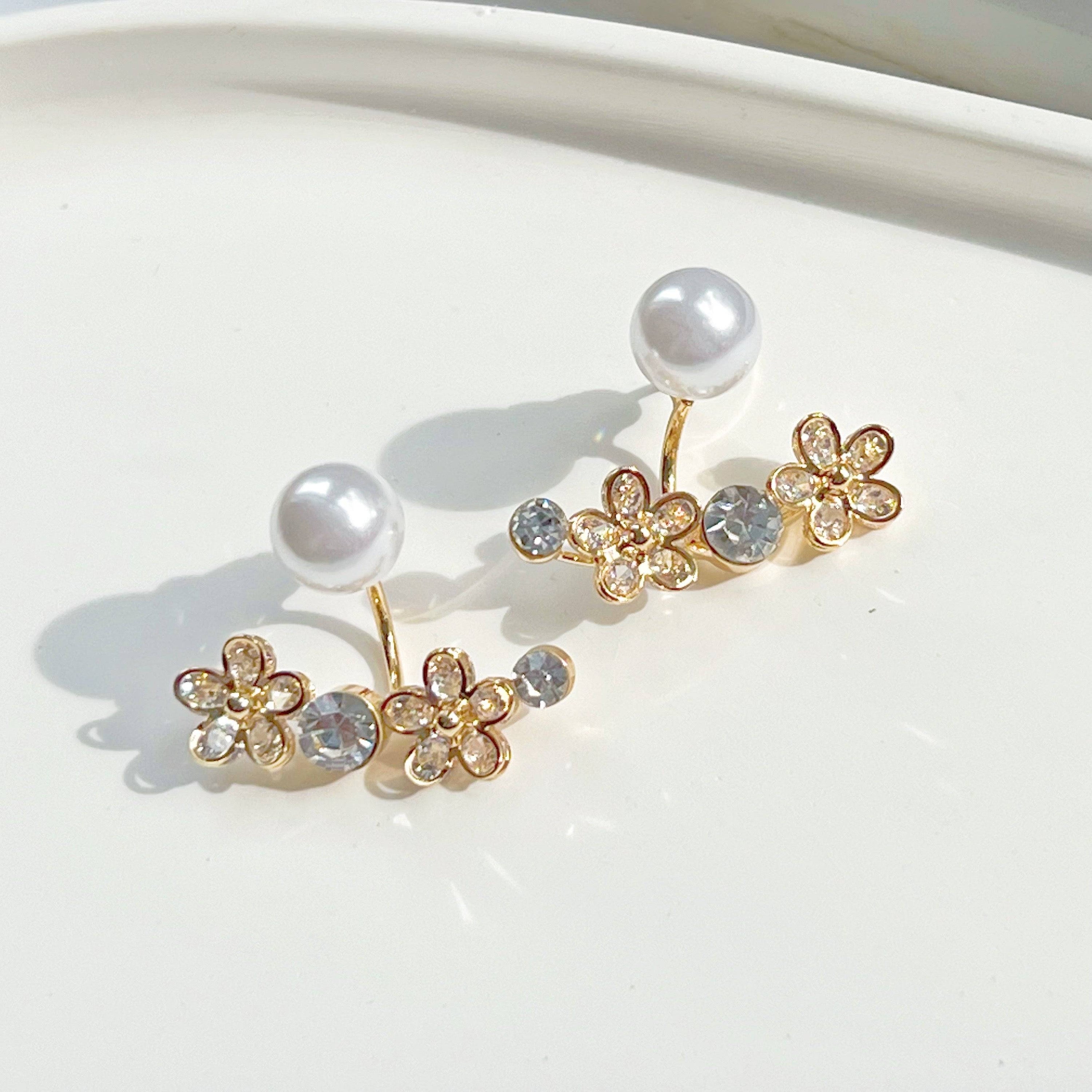 Elegant crystal flower and pearl ear jackets displayed in a gift box, showcasing their versatile design and quality materials.