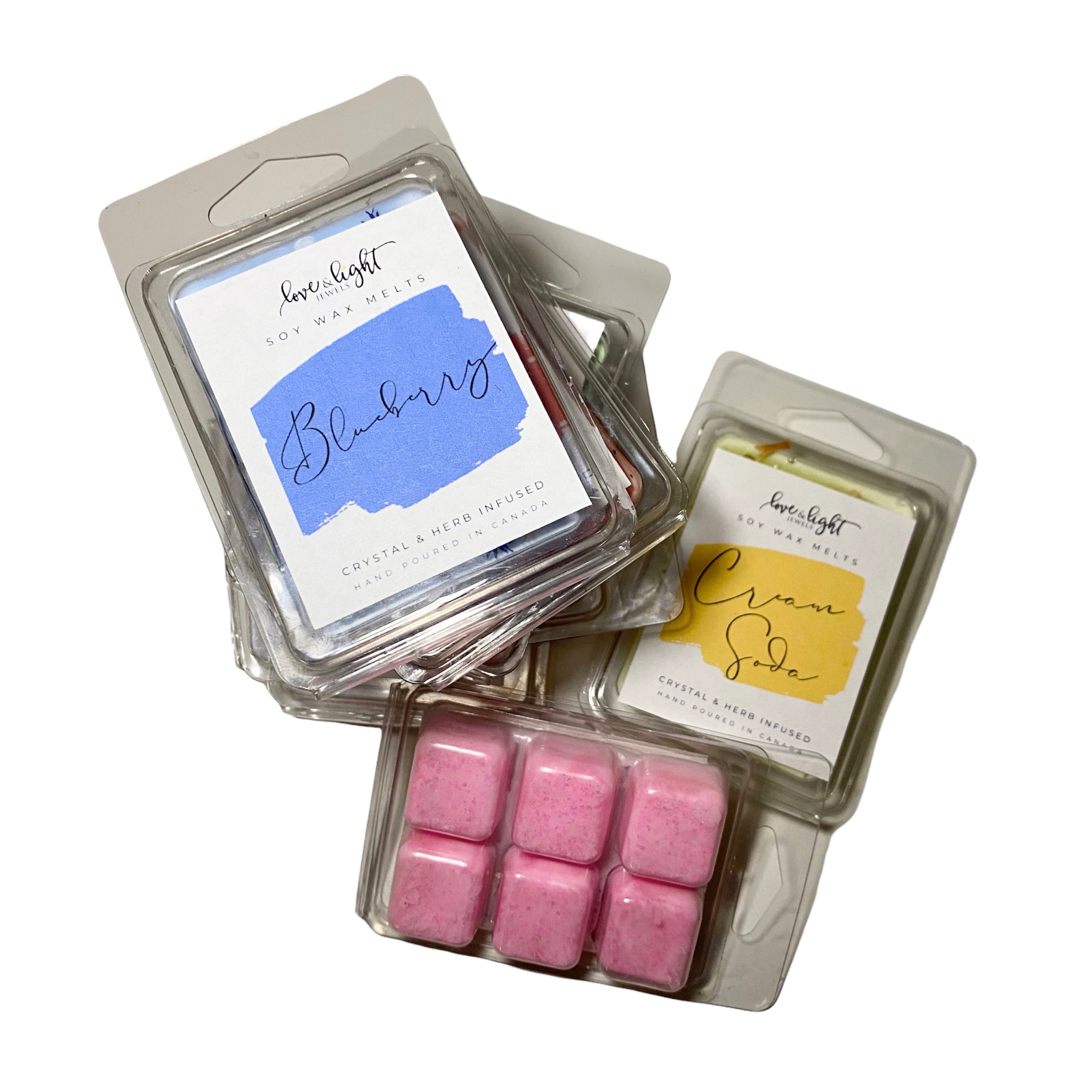 A collection of colorful Crystal & Herb Infused Soy Wax Melts arranged in a decorative dish, showcasing their unique shapes and vibrant colors.