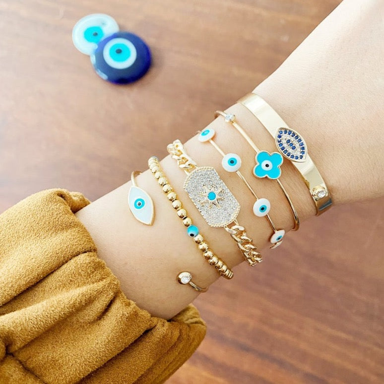 Cuff Evil Eye Bracelet featuring a white evil eye charm on a gold stainless steel cuff, showcasing its handmade craftsmanship and adjustable design.