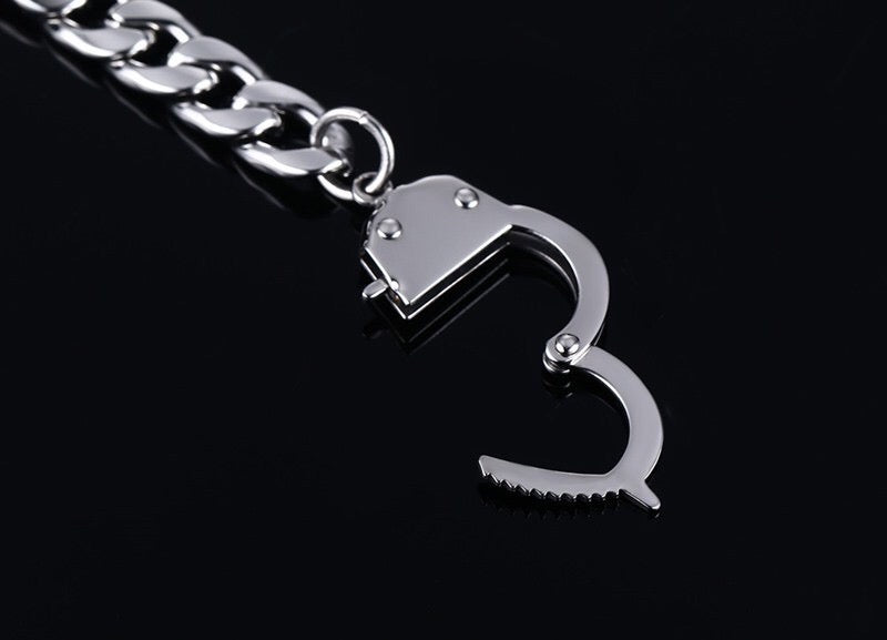 Curb handcuff bracelet made of stainless steel, featuring a sleek curb chain design and adjustable length.