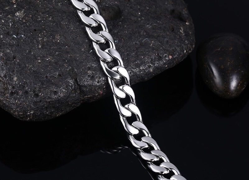 Curb handcuff bracelet made of stainless steel, featuring a sleek curb chain design and adjustable length.